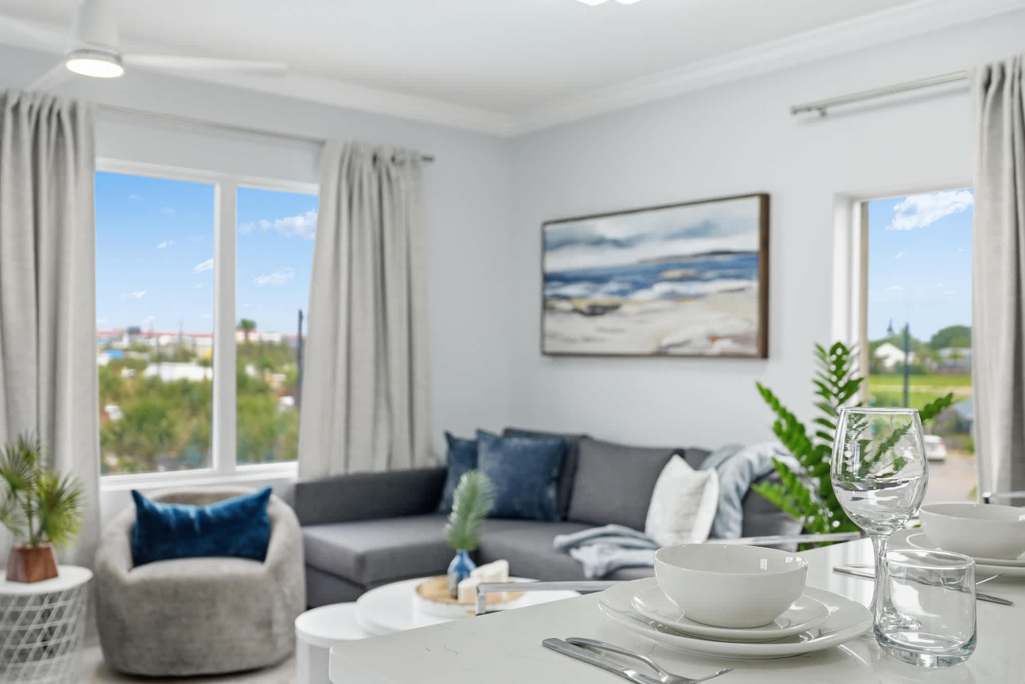 Tidewater 200 – Cozy living area with a gray sofa, dining table, and scenic window view.