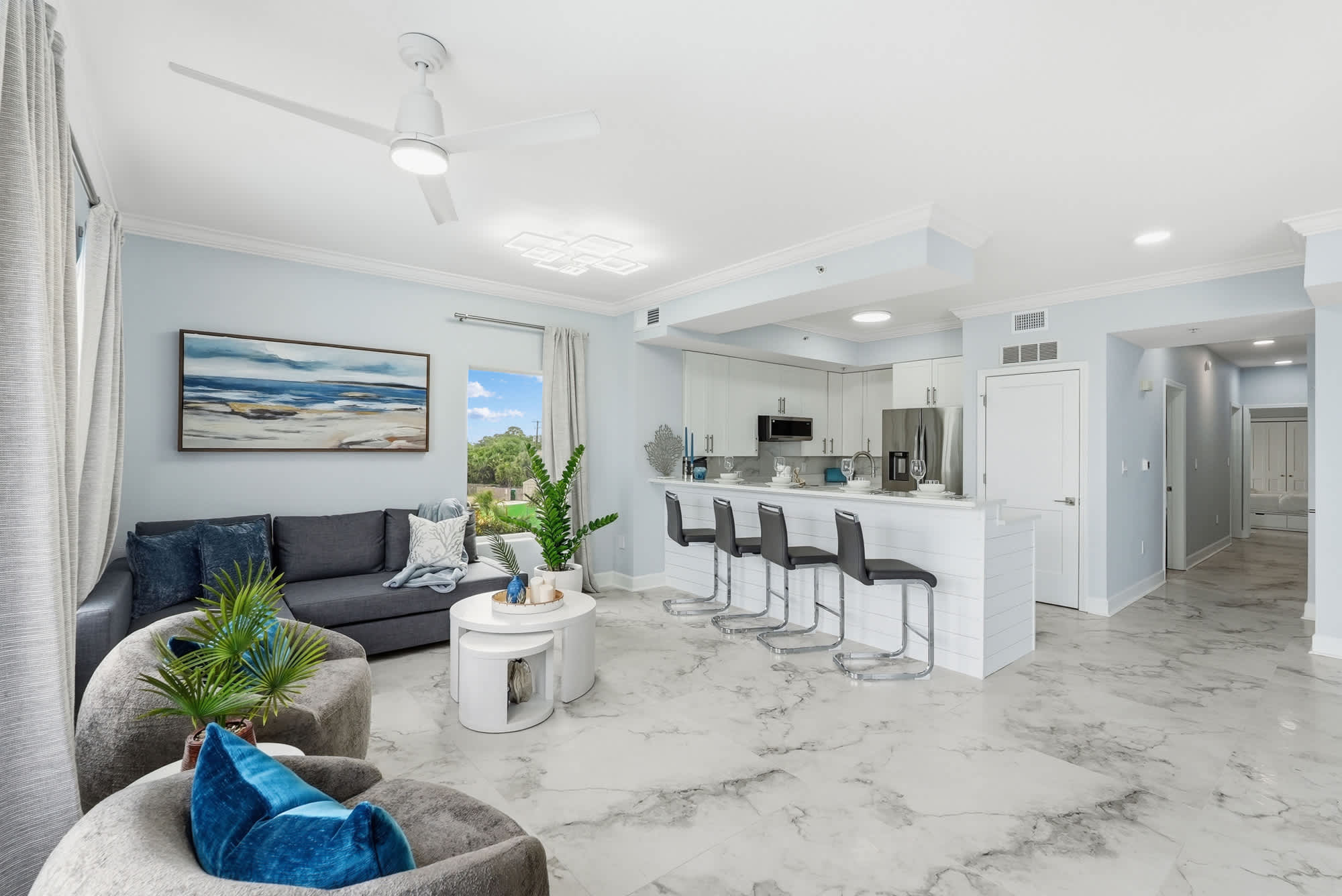 Tidewater 200 – Open living area with kitchen, seating, and window view, featuring modern decor and marble flooring.