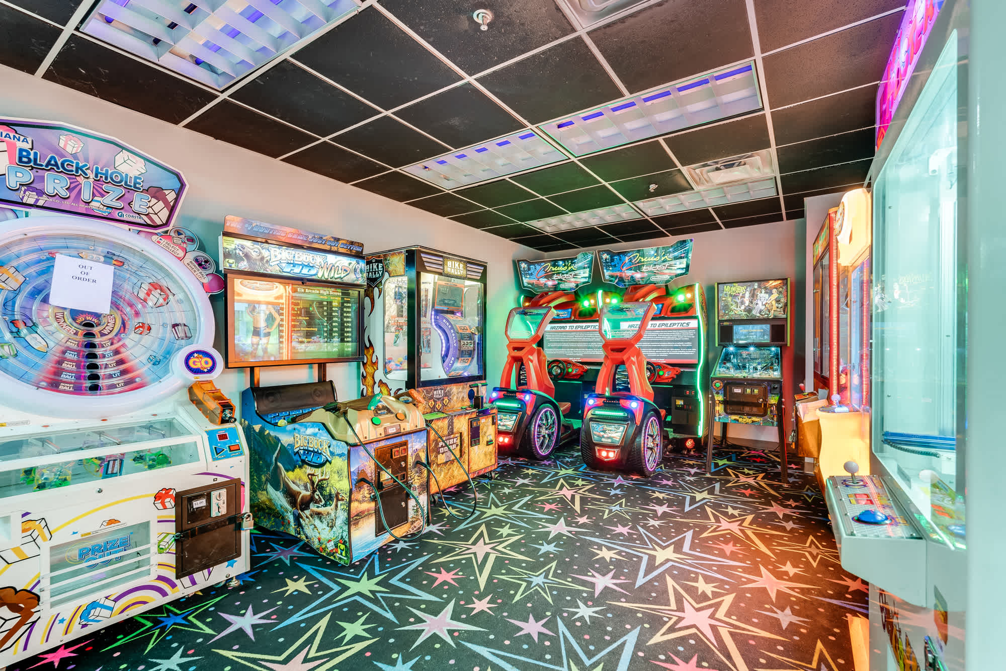 Tidewater 200 – Game room with arcade machines, vibrant star-patterned carpet, and colorful lighting.
