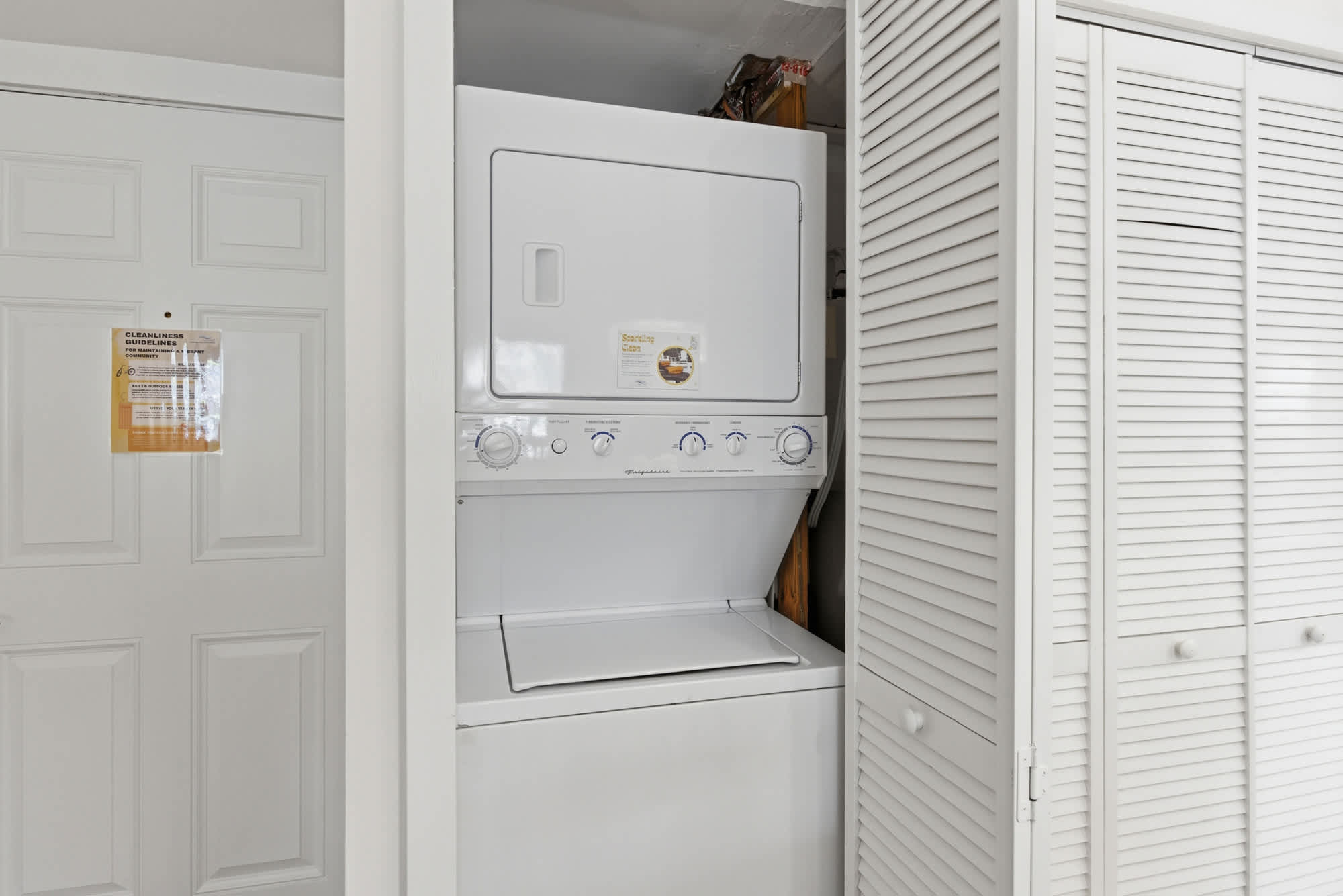 Louvered closet doors tuck away a stacked washer and dryer, providing a seamless and practical amenity for your stay. This efficient setup ensures fresh linens are always at hand within a tidy and compact nook.