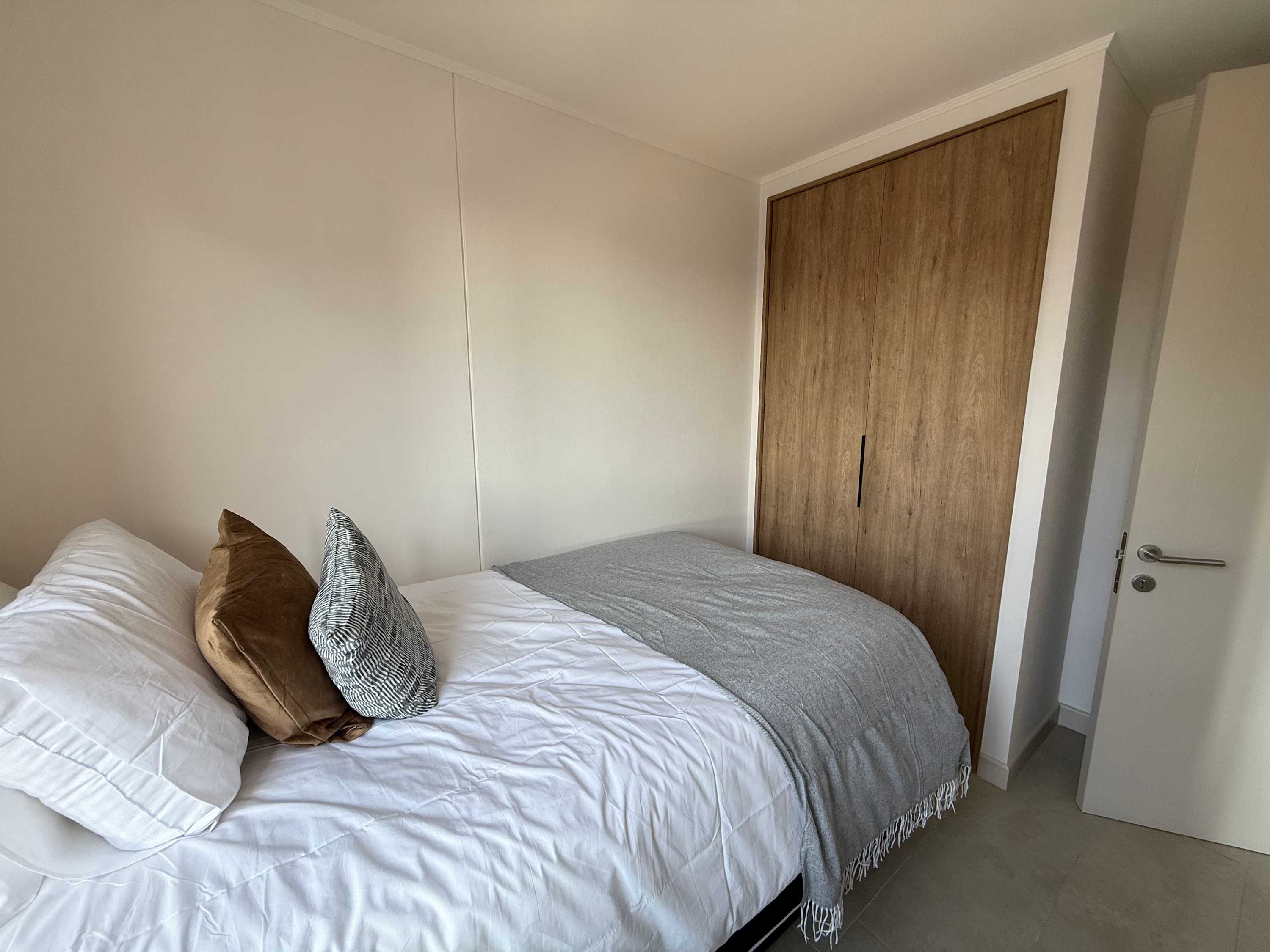 Cozy bedroom with a comfortable bed and ample storage, perfect for a restful stay.