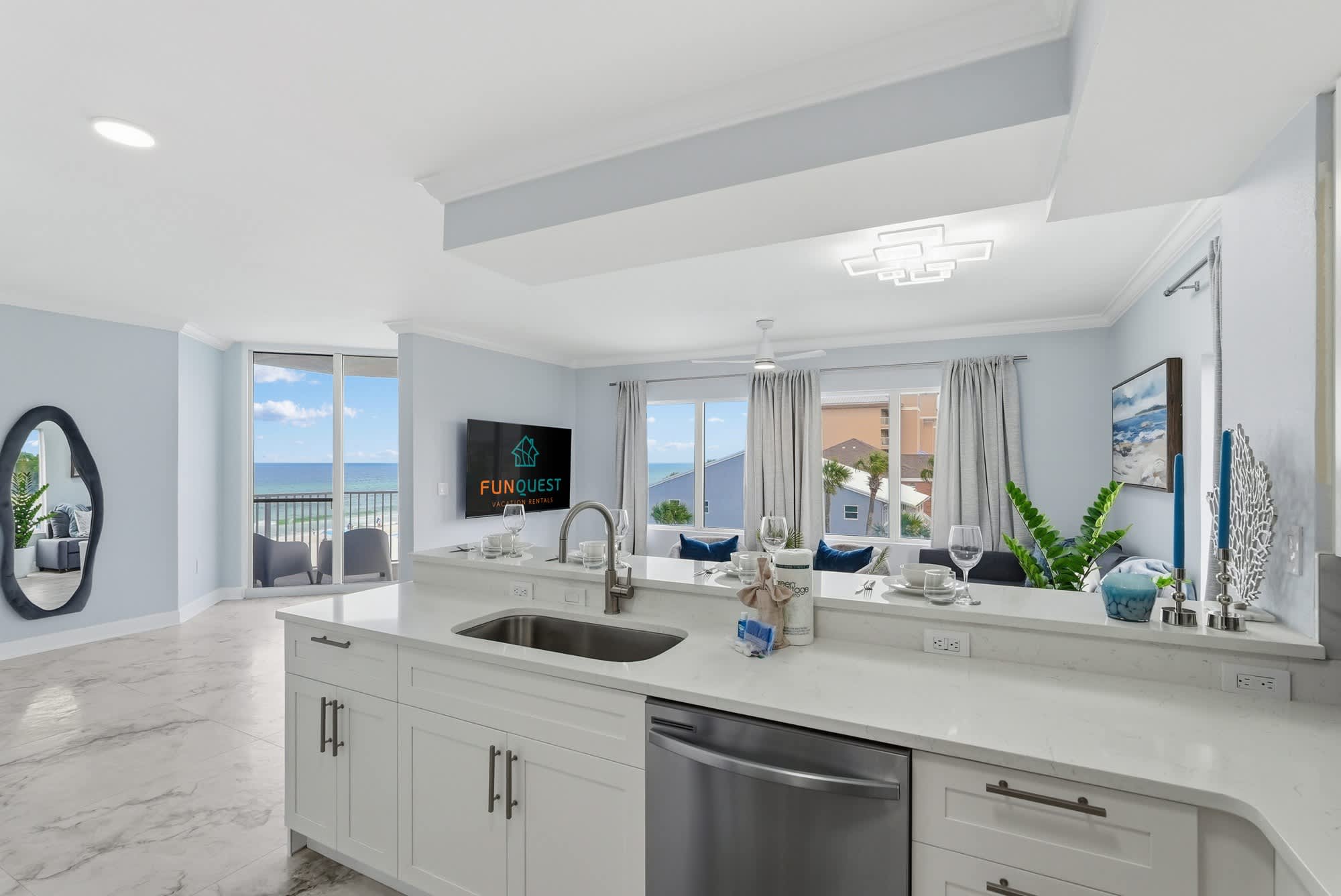 Tidewater 200 – Modern kitchen and living area with ocean view and balcony access.
