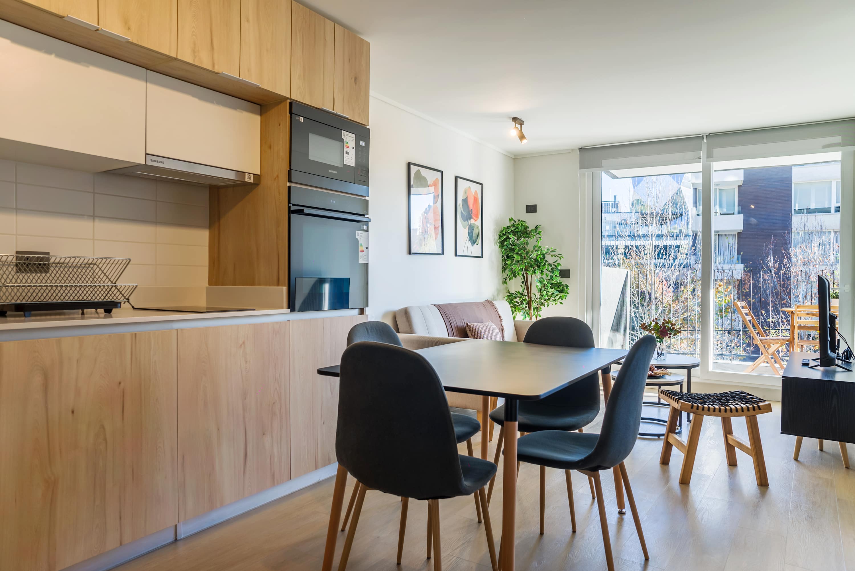 Bright and modern living space with a fully equipped kitchen and cozy balcony, perfect for relaxation.