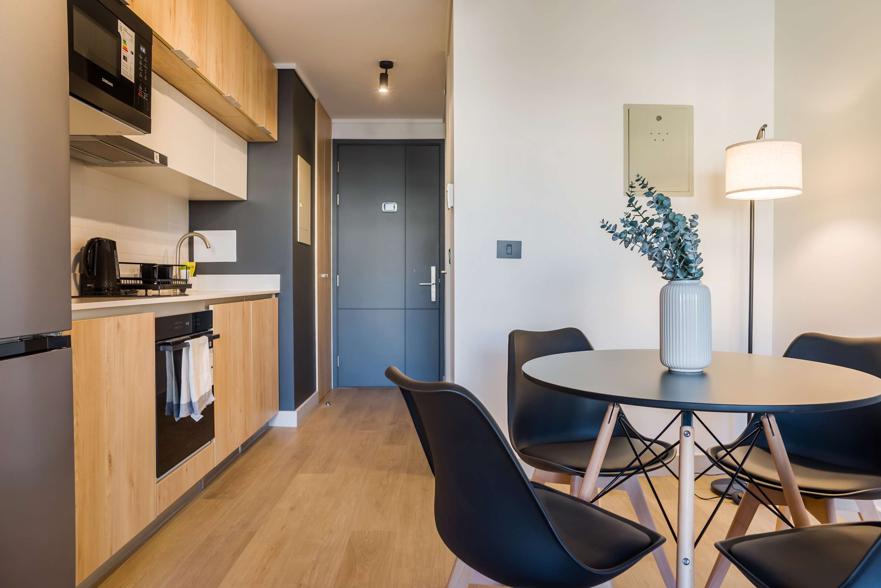 Modern kitchen with sleek appliances and a cozy dining area, perfect for enjoying meals in style.