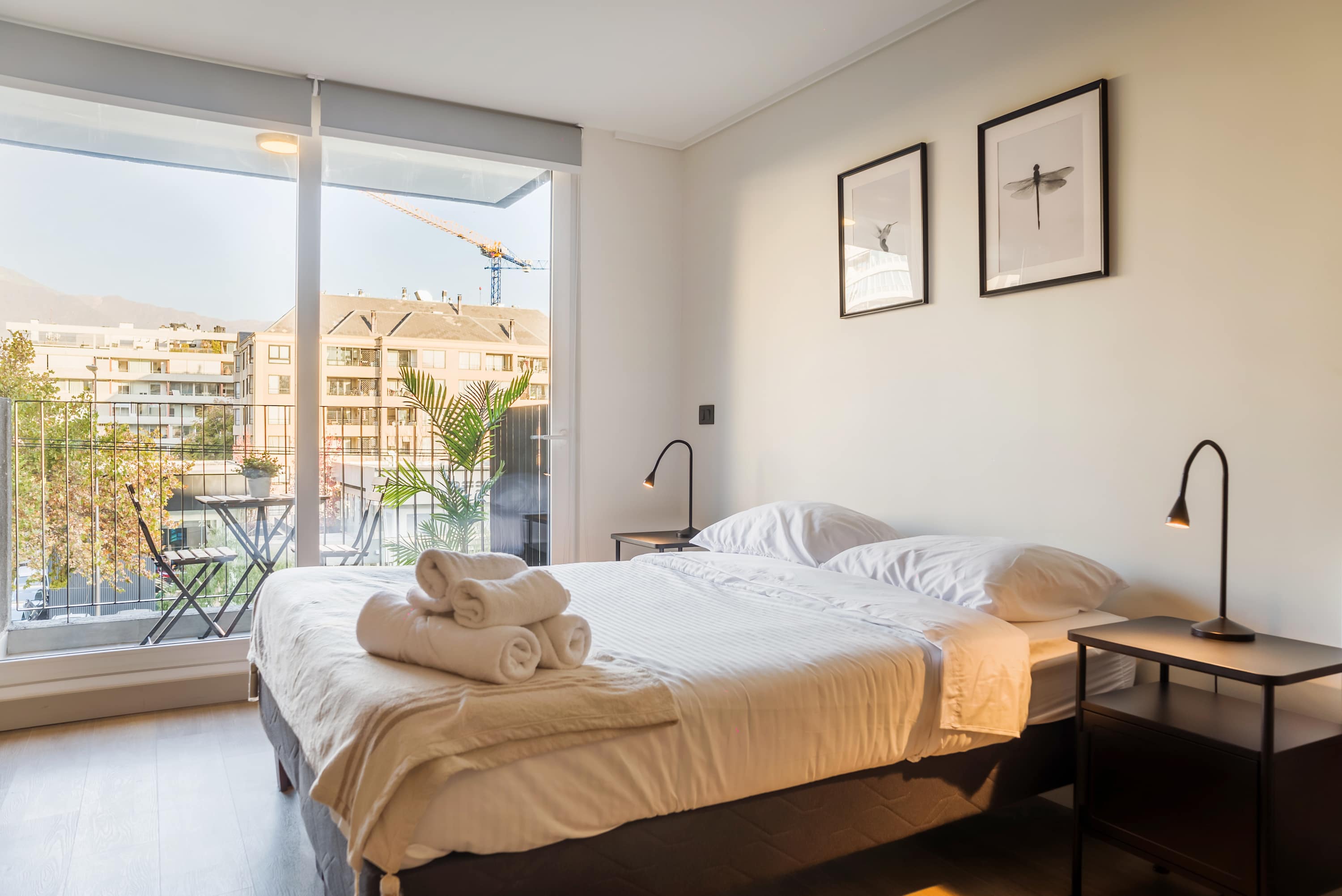 Bright and cozy bedroom with city views and a private balcony, perfect for a relaxing stay.