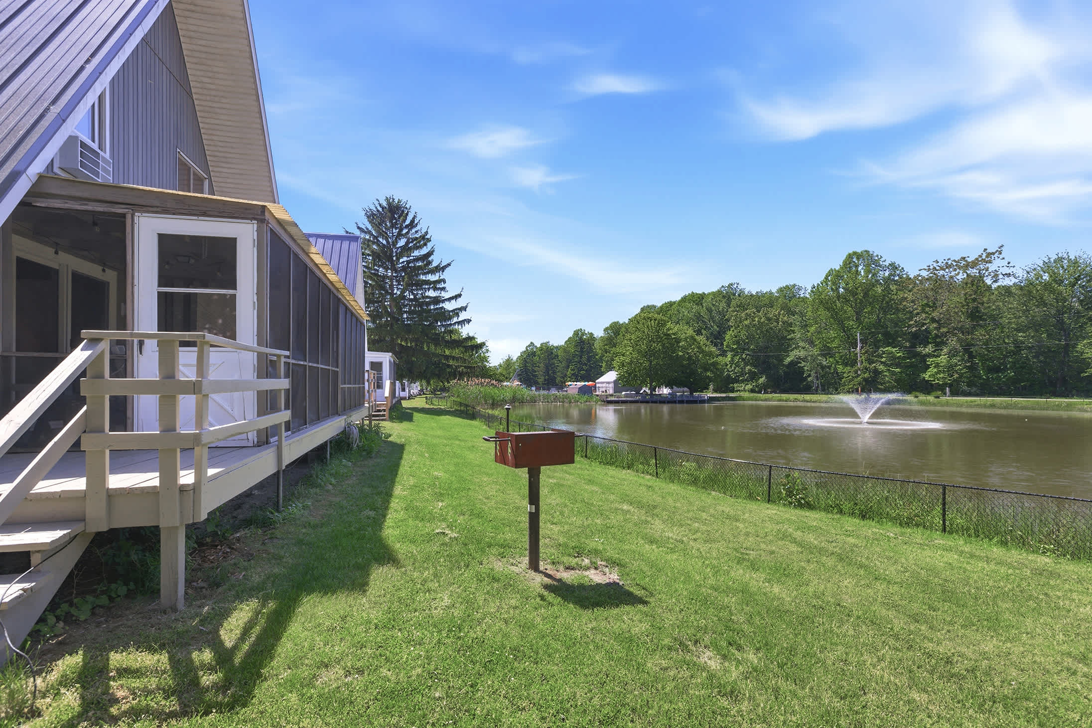 Outdoor cooking area with waterfront views and open lawn space.