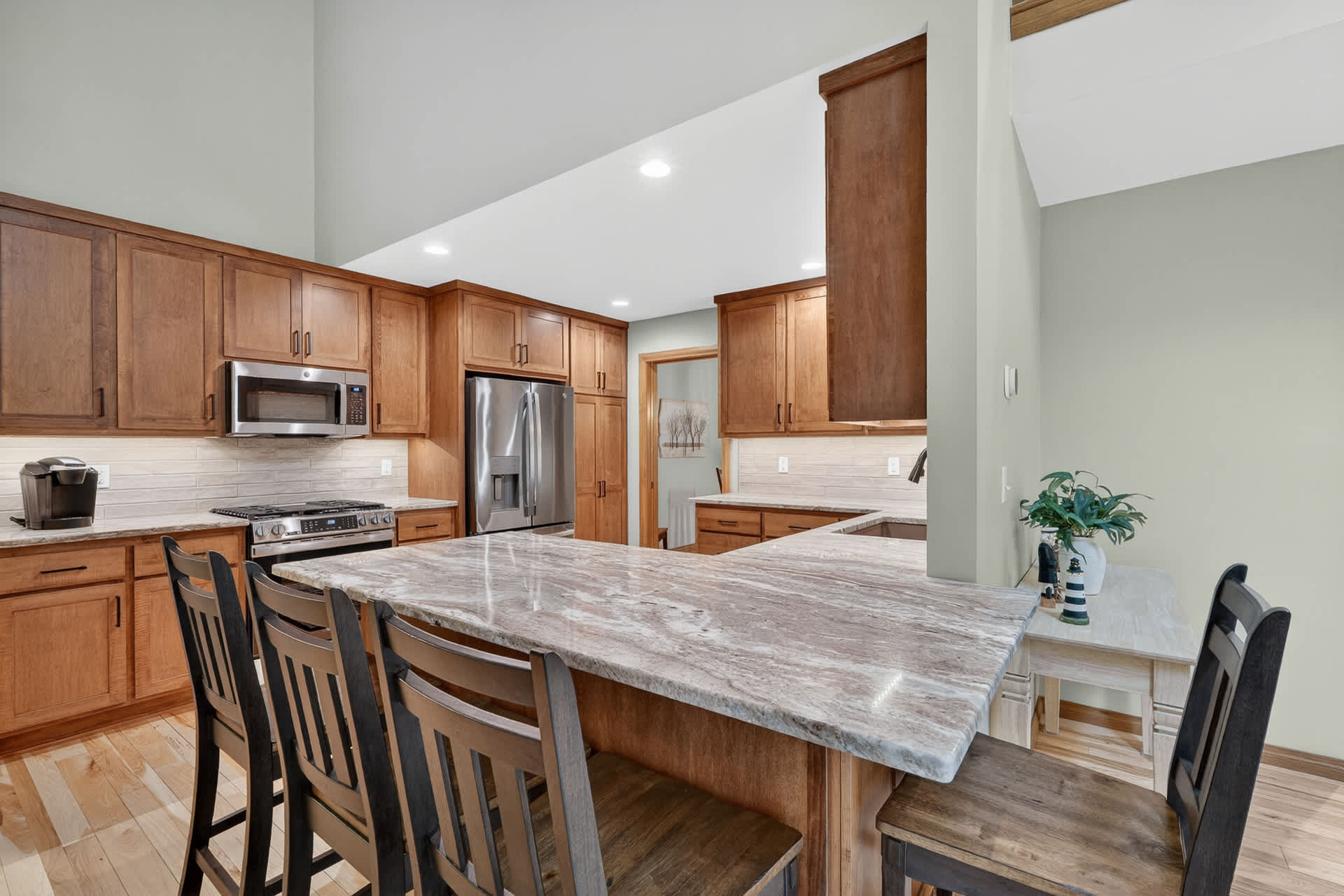 Step into your vacation kitchen where gleaming marble countertops and warm wood cabinetry invite you to gather around the spacious island for morning coffee or evening meals with loved ones.
