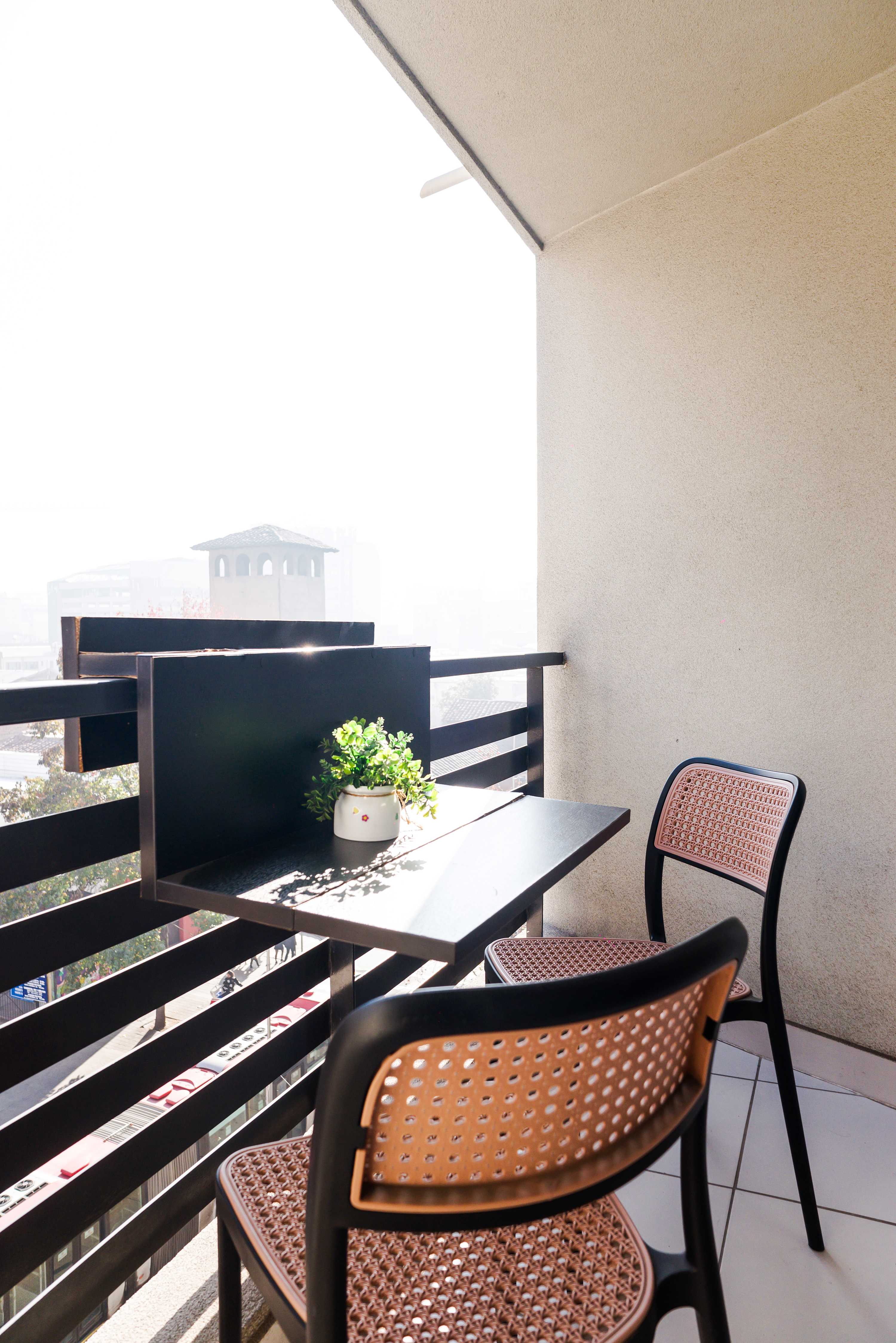 Enjoy your morning coffee with a city view from this cozy balcony retreat.