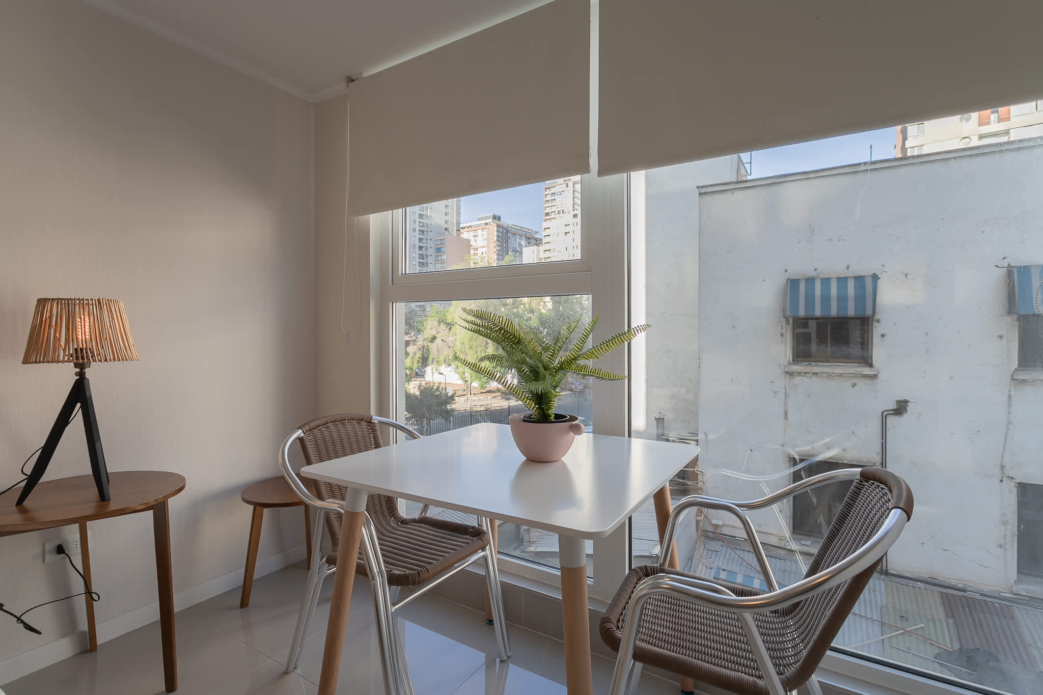 Cozy dining nook with natural light and city views, perfect for a relaxing meal.