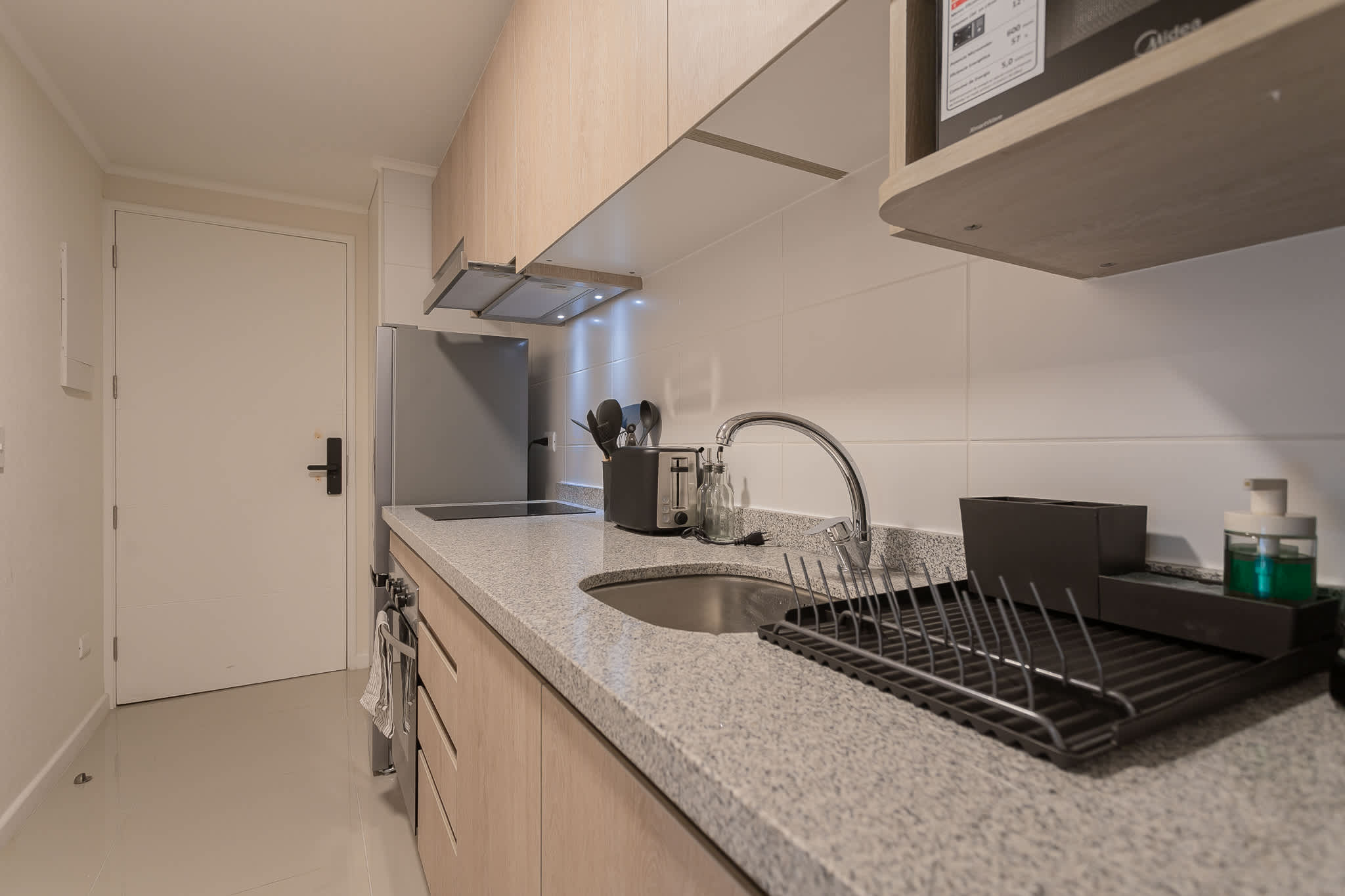 Modern kitchenette with sleek appliances and ample counter space, perfect for preparing meals in your cozy studio retreat.