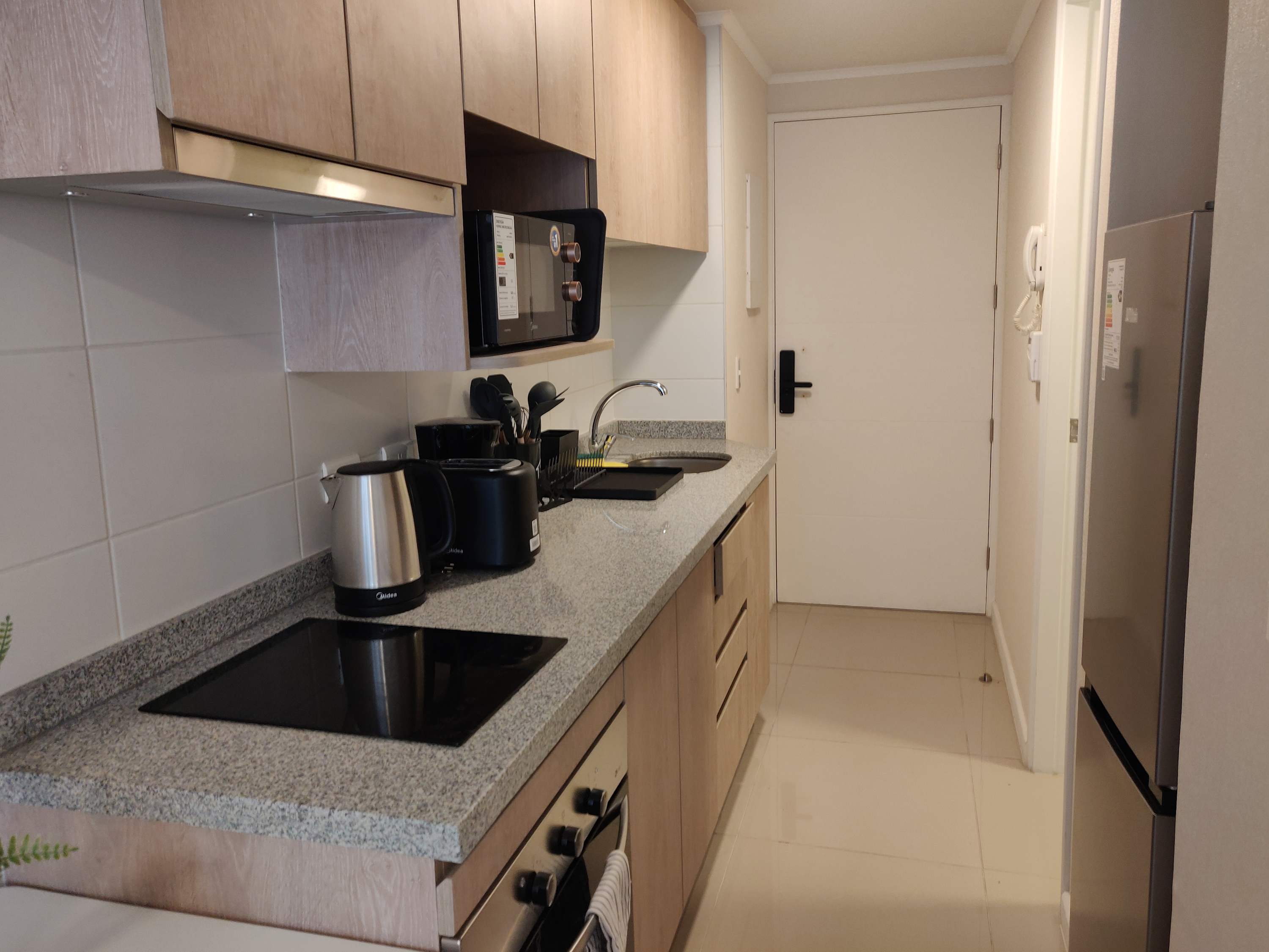 Modern and efficient kitchen with all essentials for a comfortable stay in a cozy studio apartment.