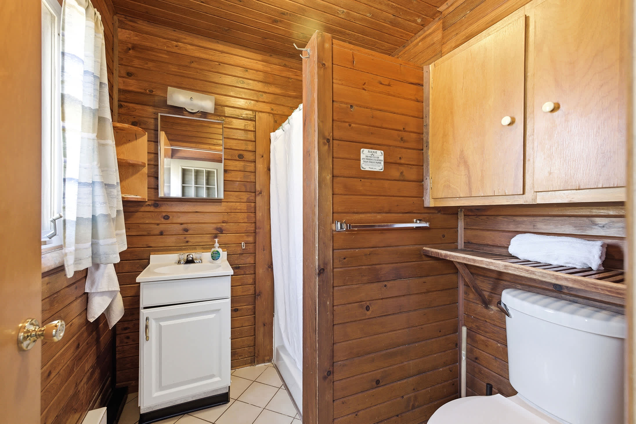Main-level bathroom with a walk-in shower offers convenience between beach days.