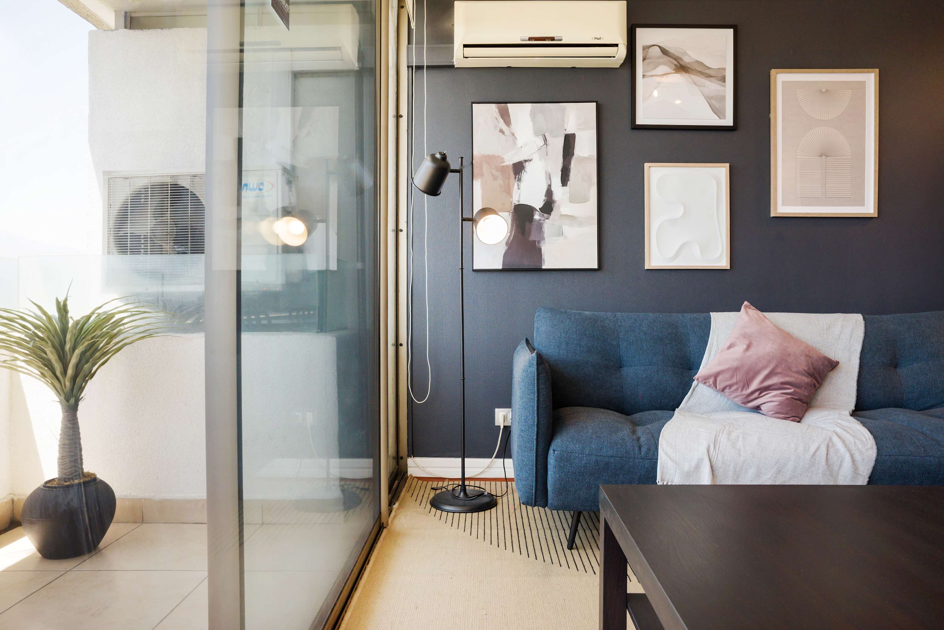 Stylish living area with modern decor and a cozy balcony, perfect for relaxation.