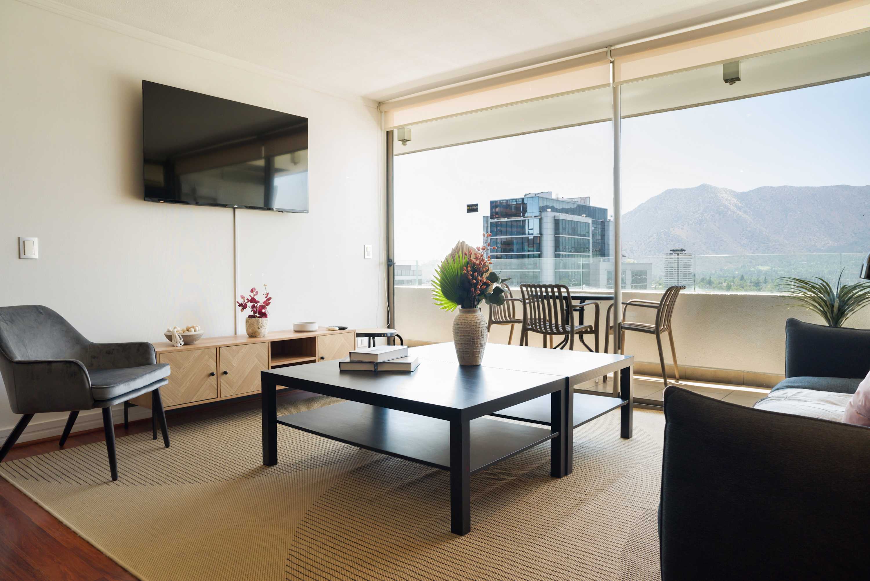 Enjoy breathtaking mountain views from this stylish living room with modern amenities and a cozy balcony.
