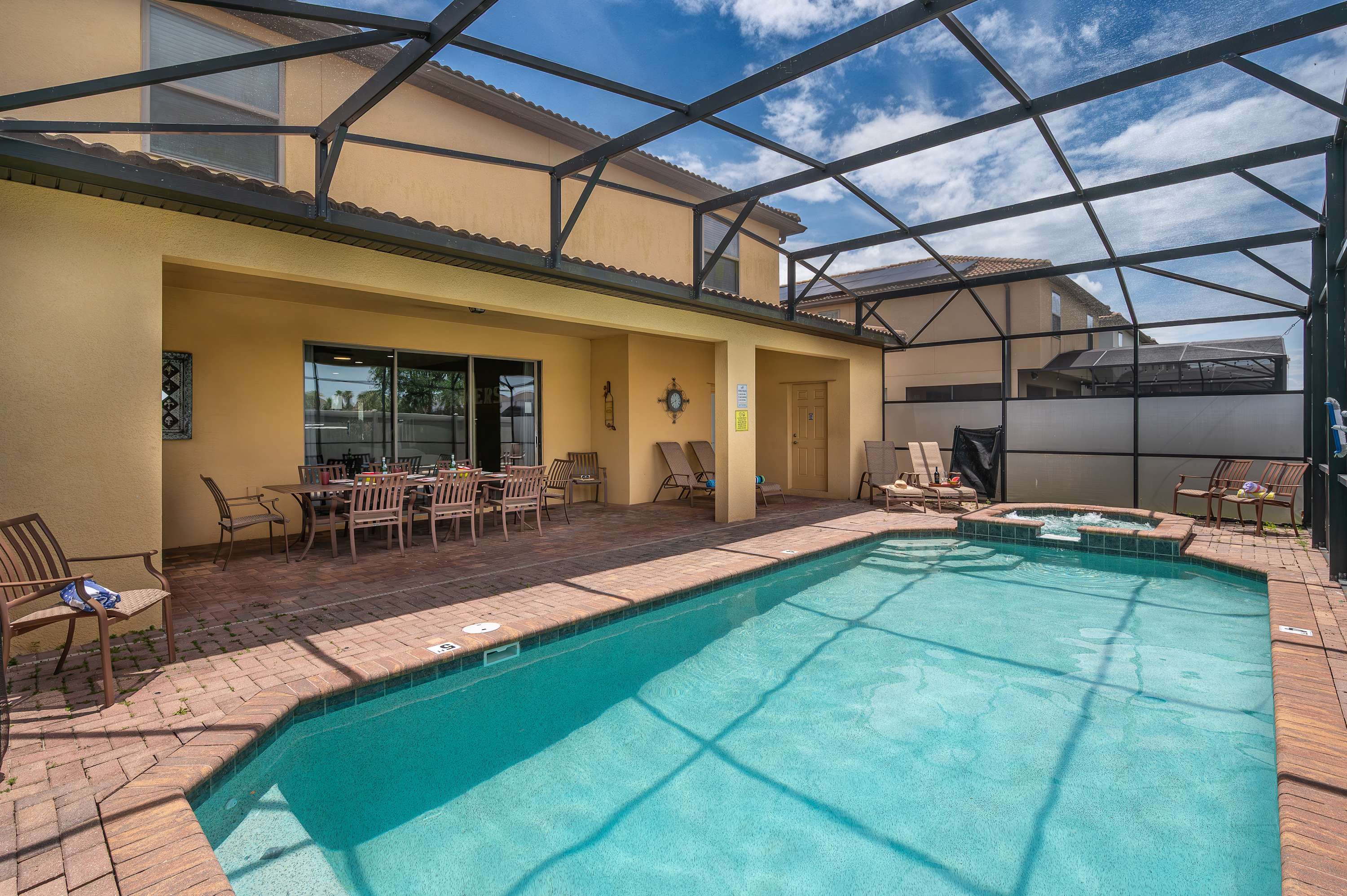 Screened-in pool gleaming under the sun — your own private splash zone.