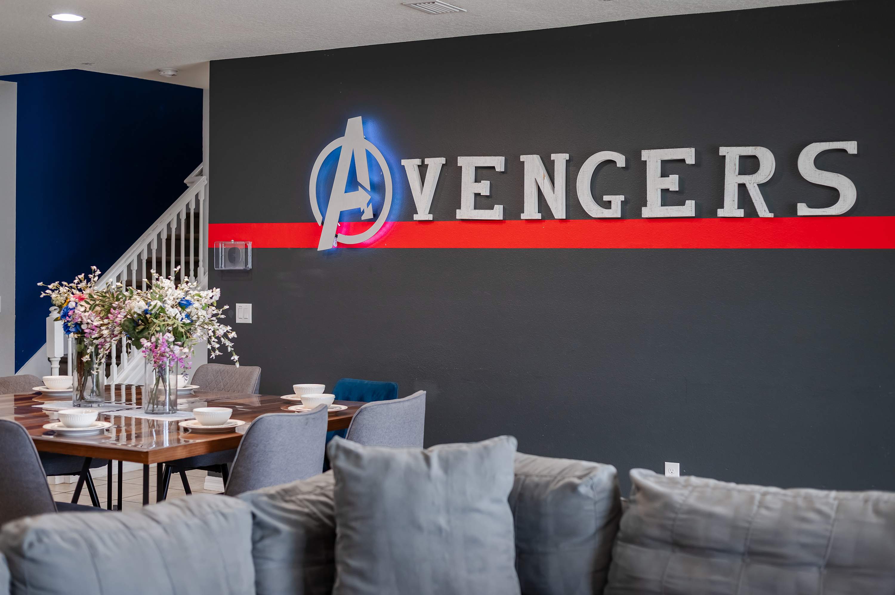Avengers-themed lounge w/ bold wall art & cozy seating — perfect for unwinding w/ the squad.