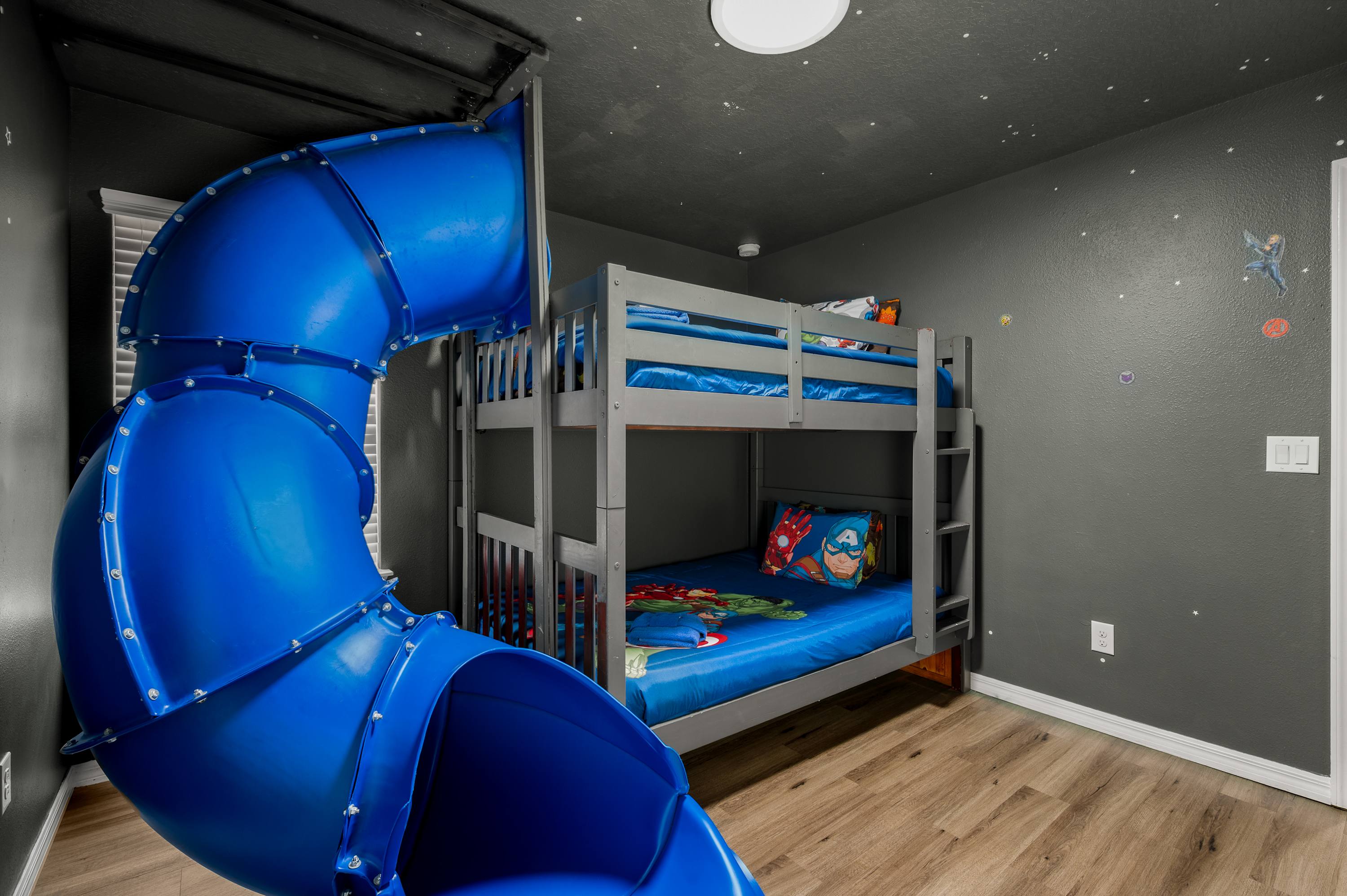 Kids' bunk room w/ a built-in blue slide — bedtime just got a whole lot more exciting.