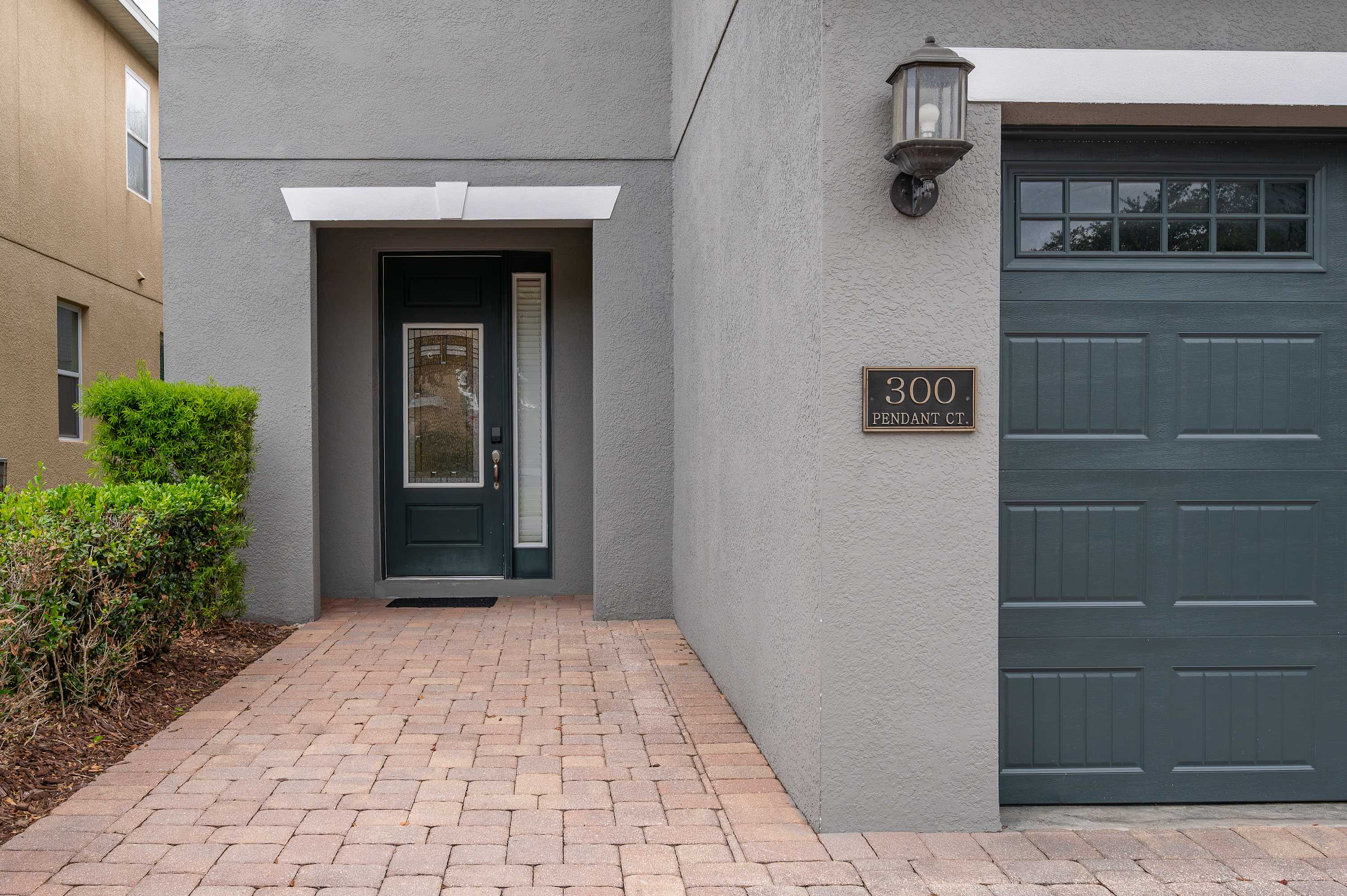 Modern entryway with a decorative glass front door and attached garage.