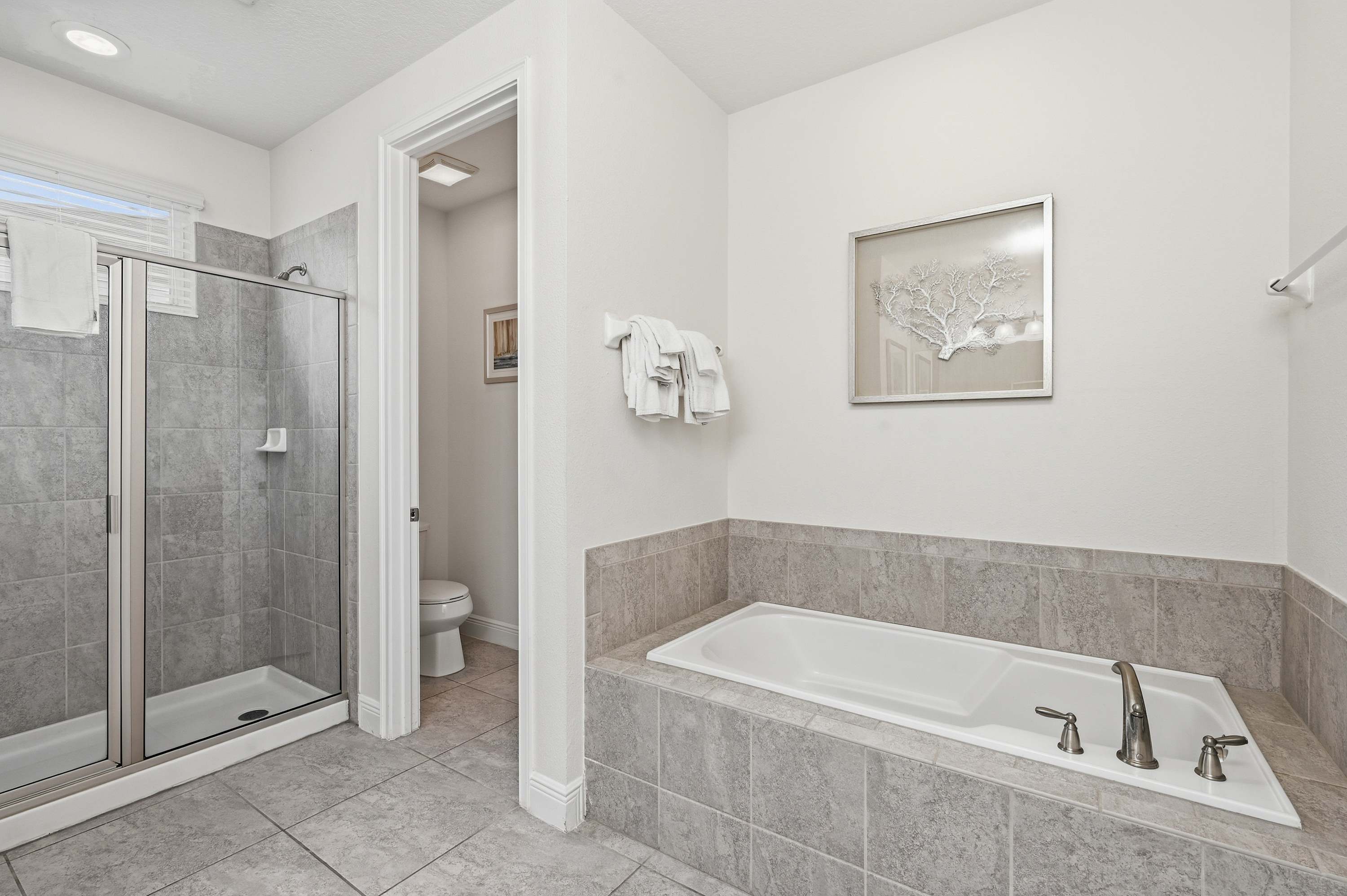 Modern bathroom featuring a tiled walk-in shower and a spacious bathtub.