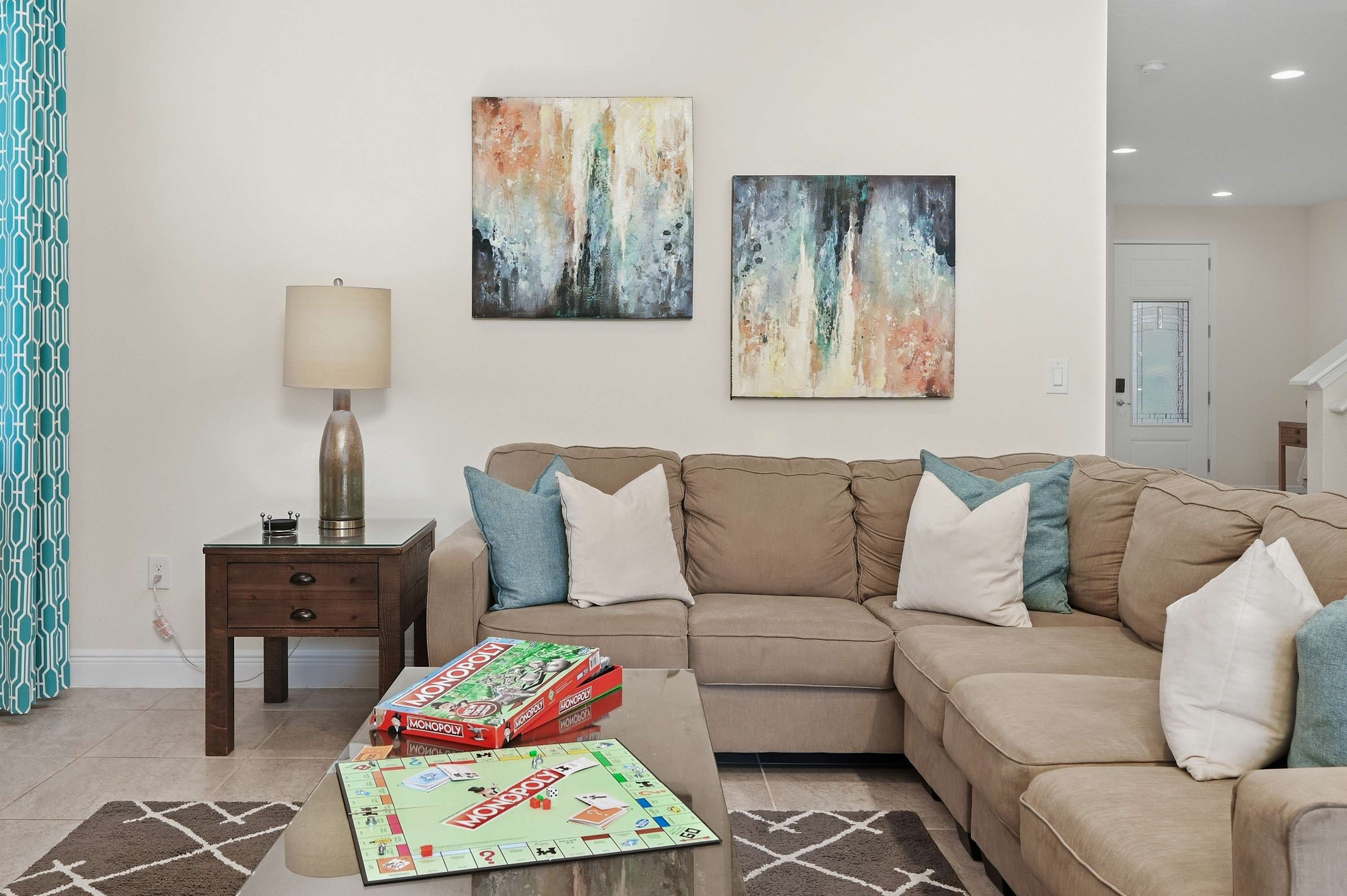Cozy living room with a sectional sofa, abstract wall art, and a game-ready coffee table.