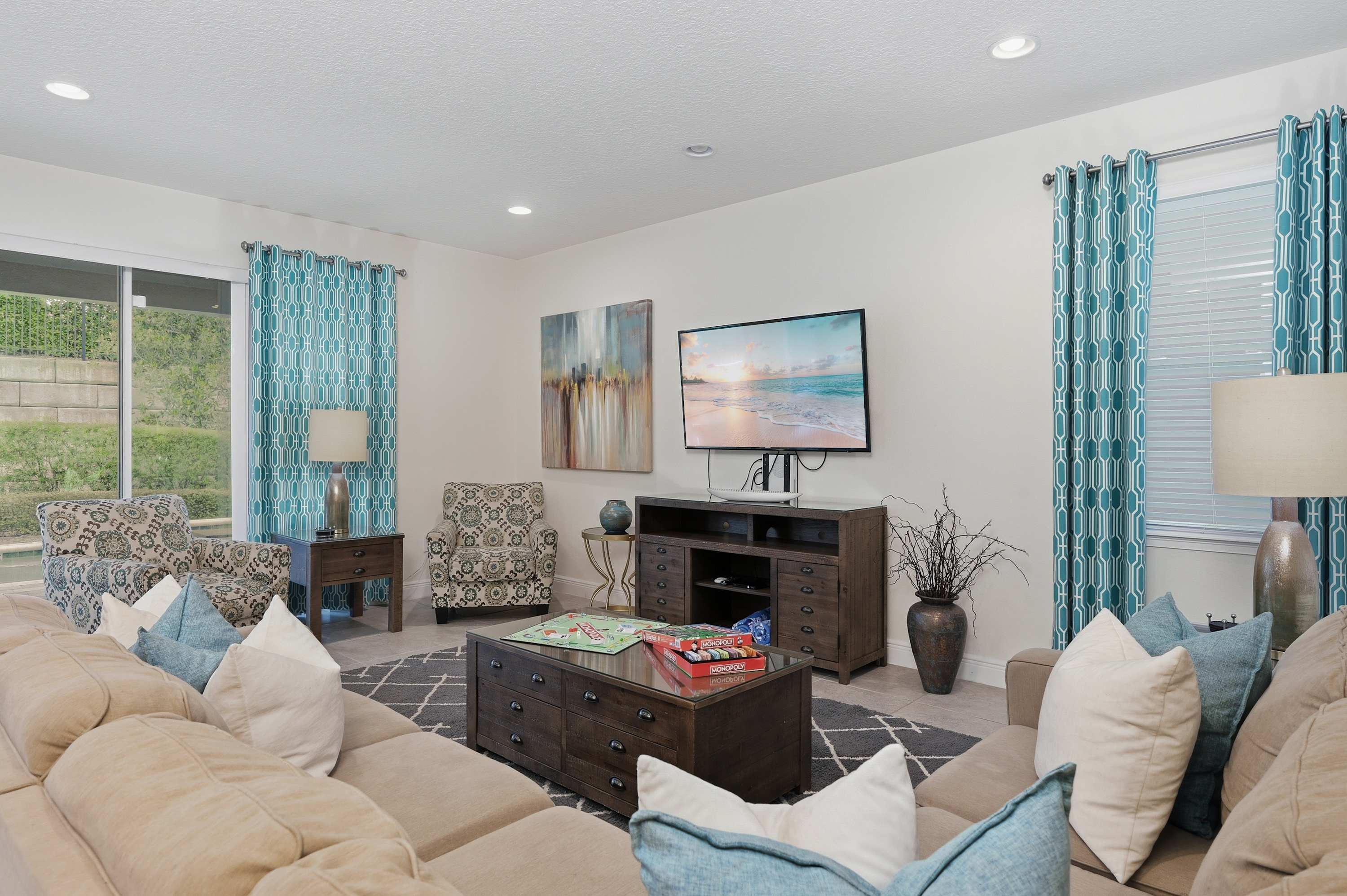 Relax in this cozy living room featuring patterned armchairs and a large flat-screen television.