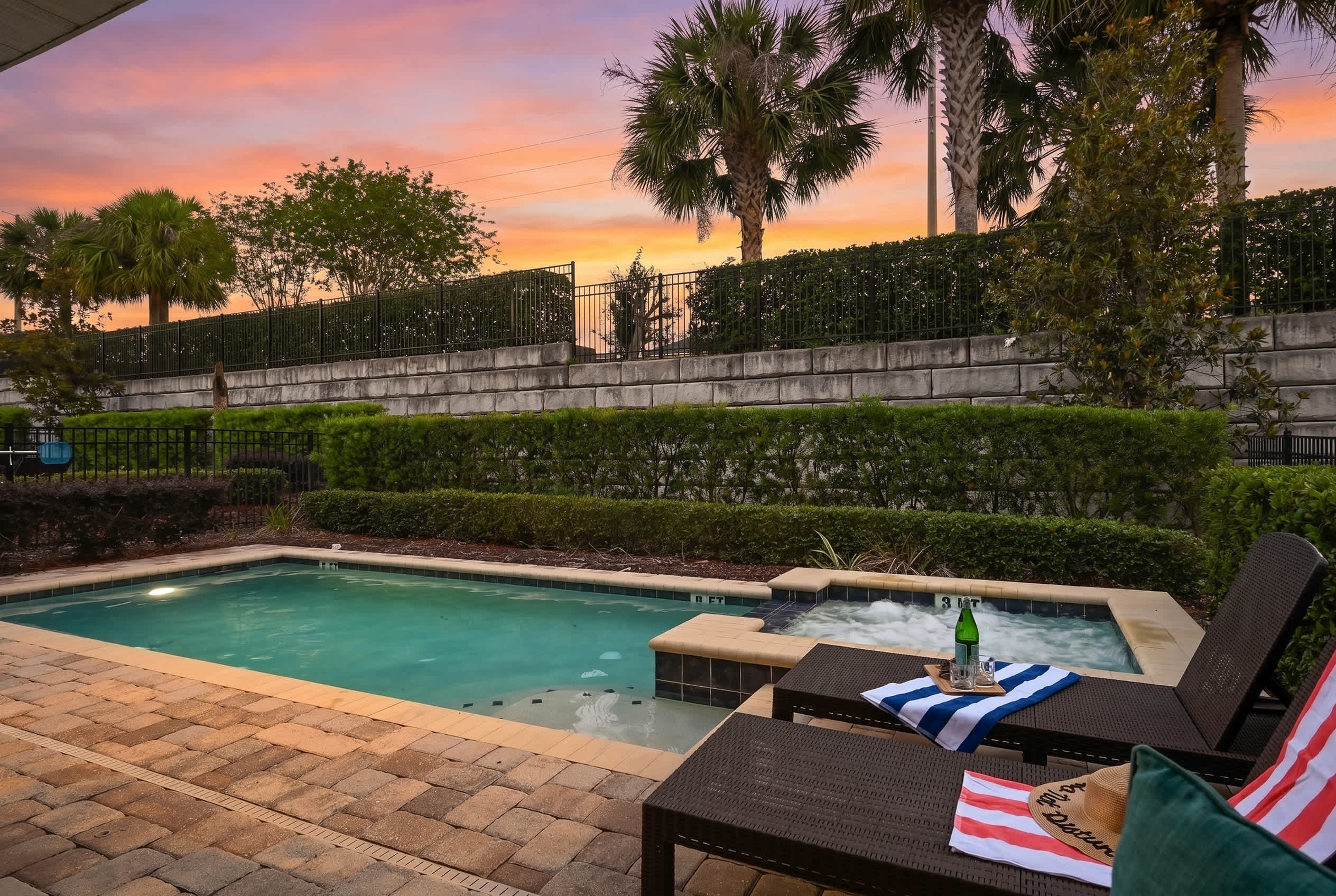 Relax by the pool and hot tub at sunset in this serene outdoor space.