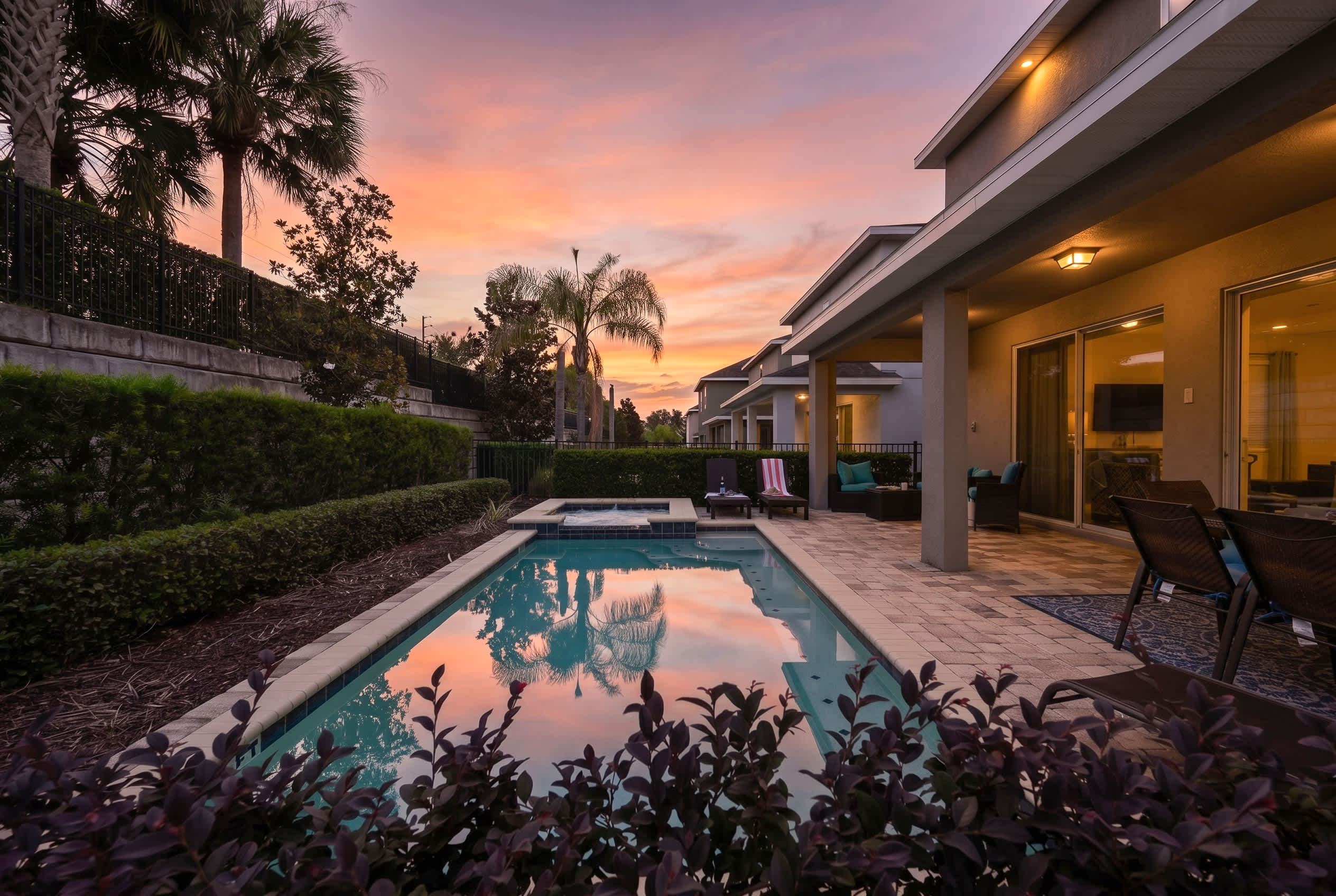 Relax by the modern pool and spa area at sunset with comfortable outdoor seating.