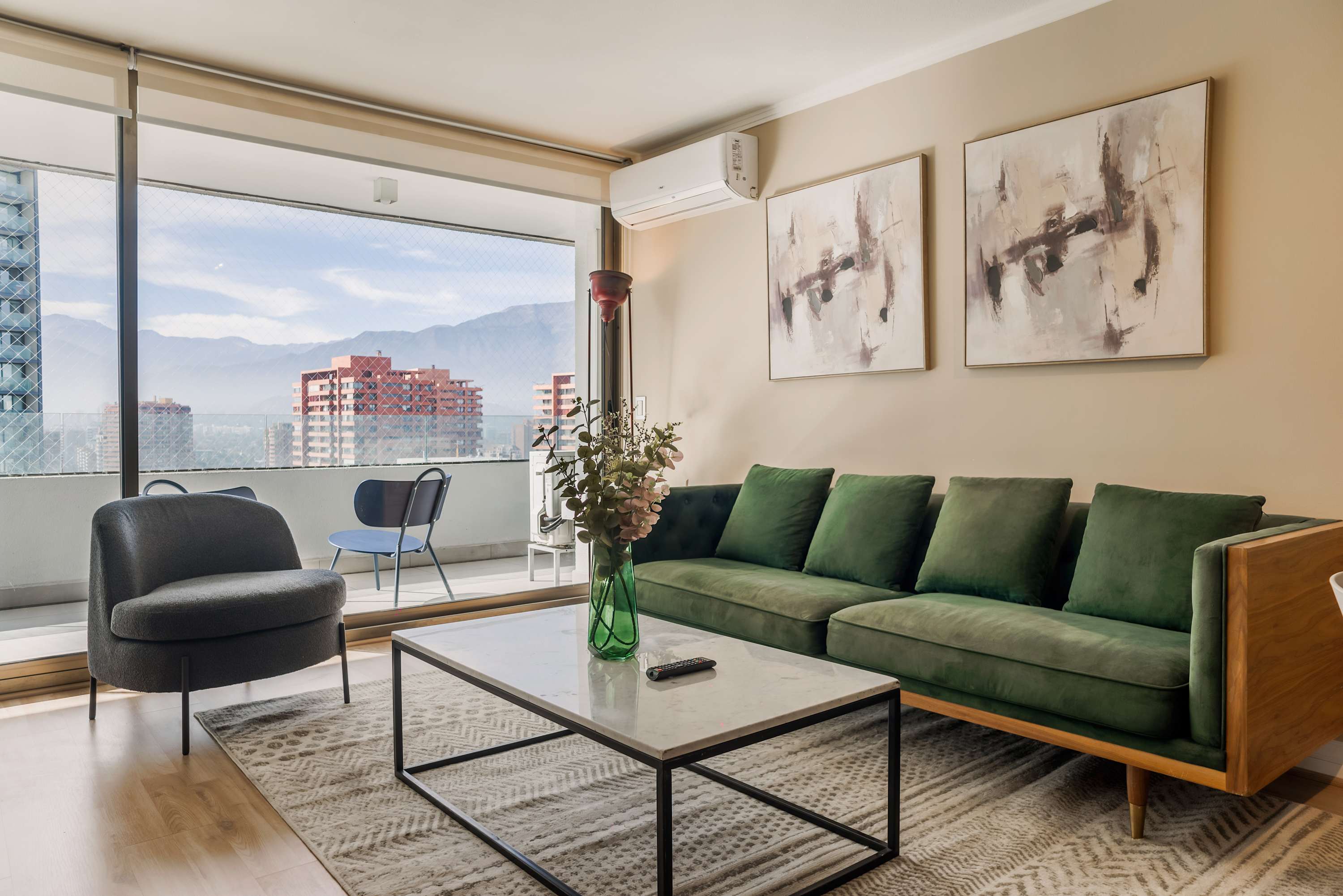 Relax in a stylish living room with stunning city and mountain views, perfect for unwinding after a day of exploring Santiago.