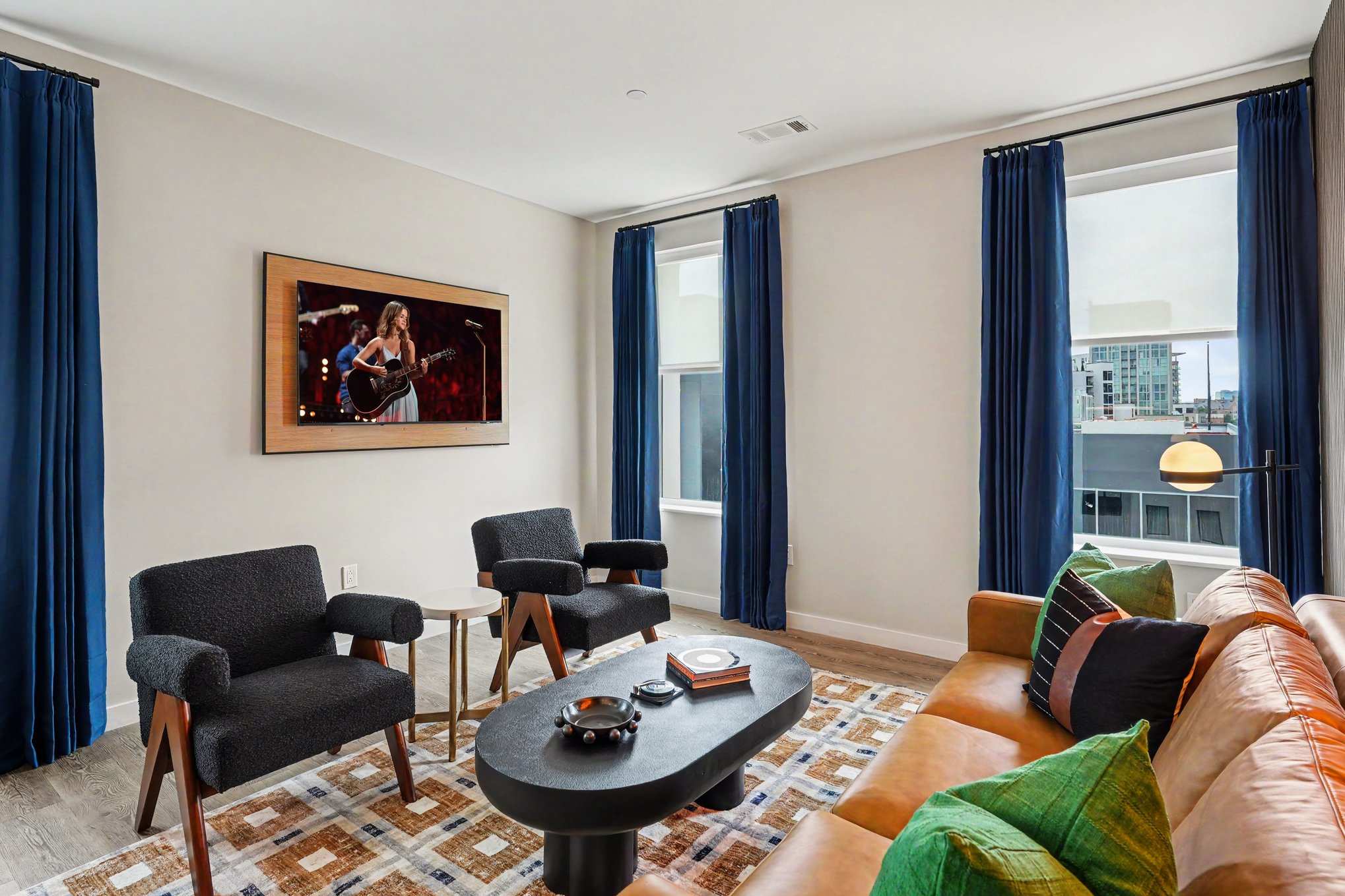 Bright and open living area featuring a smart TV and plush furnishings. Connects to the dining area and kitchen.