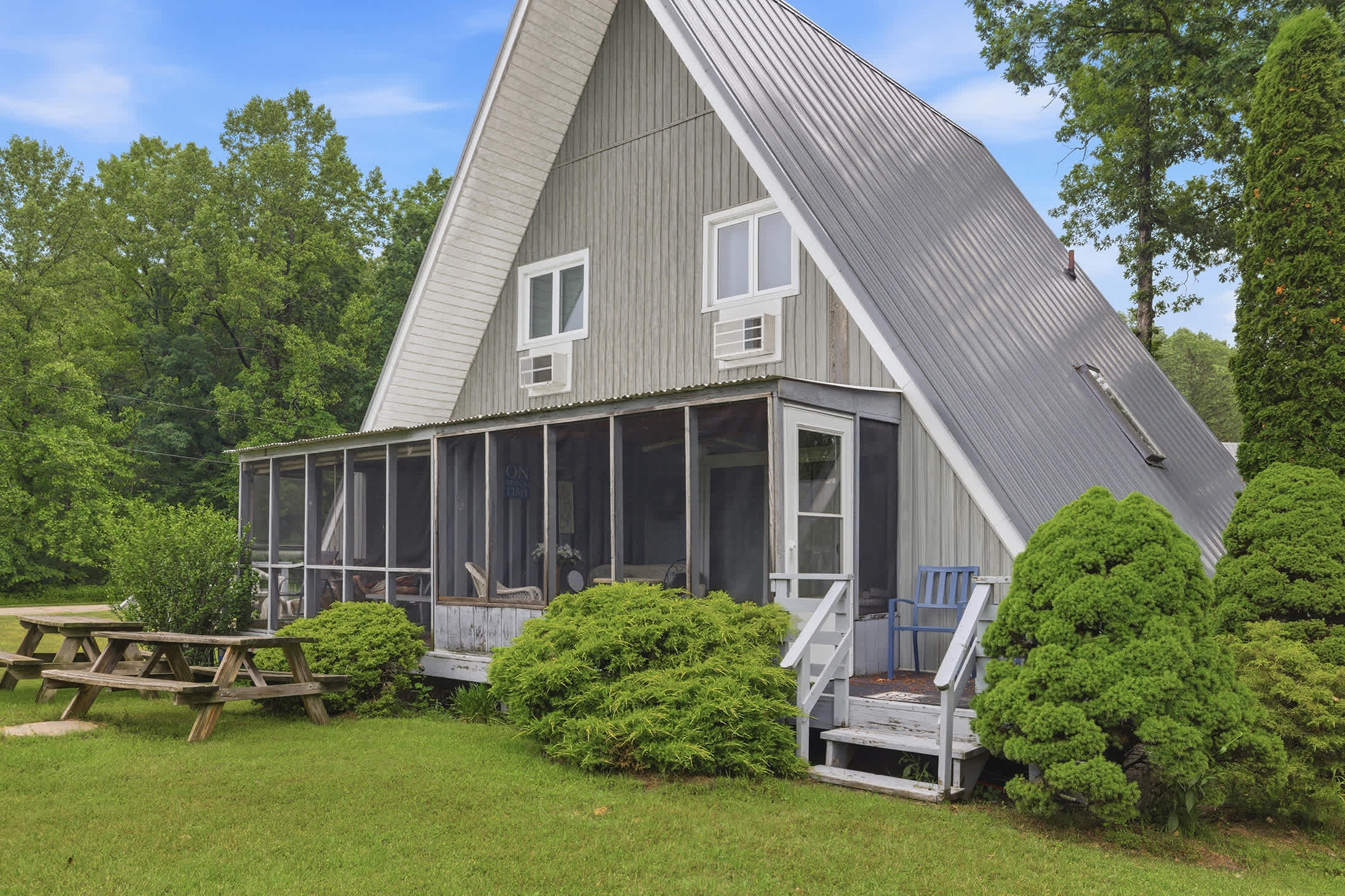 Chalet #68 features a screened porch, outdoor seating, and picnic area, giving families extra space to relax, dine, and enjoy the resort grounds between beach days and activities.