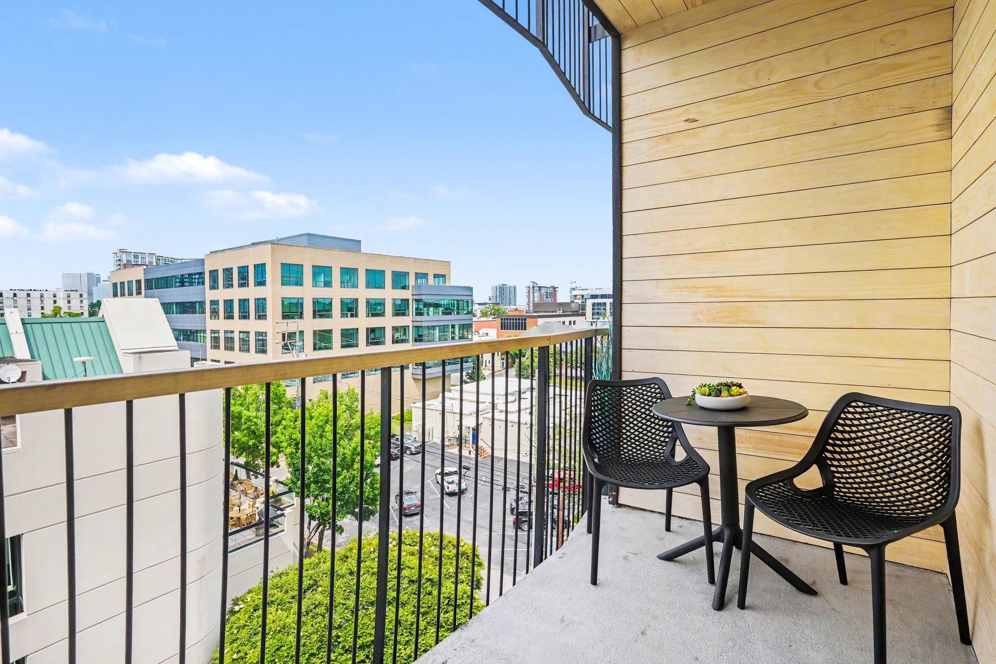 Private balcony with outdoor seating and views of downtown.