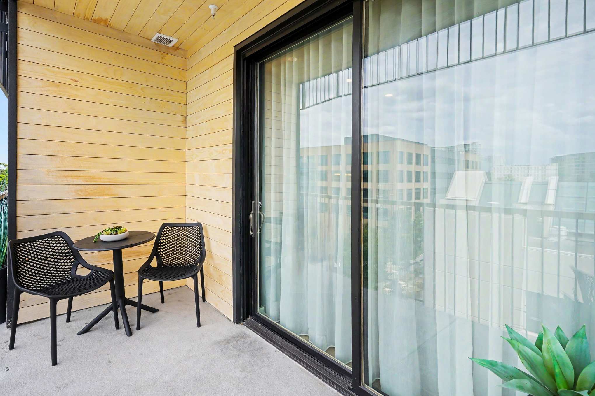 Private balcony with outdoor seating and views of downtown.