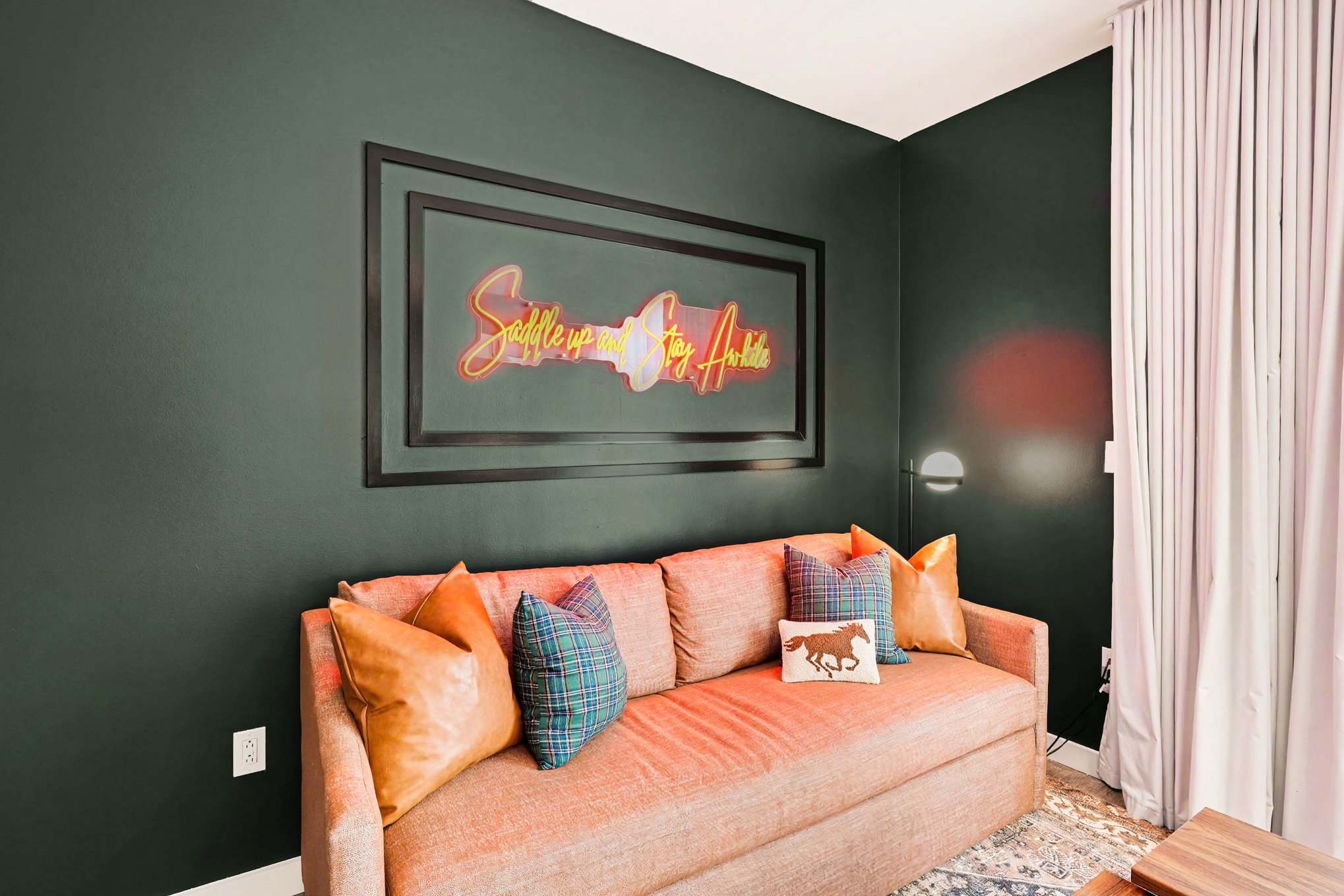 Bright and open living area featuring a smart TV, plush furnishings, and access to the private balcony. Connects to the dining area and kitchen.
