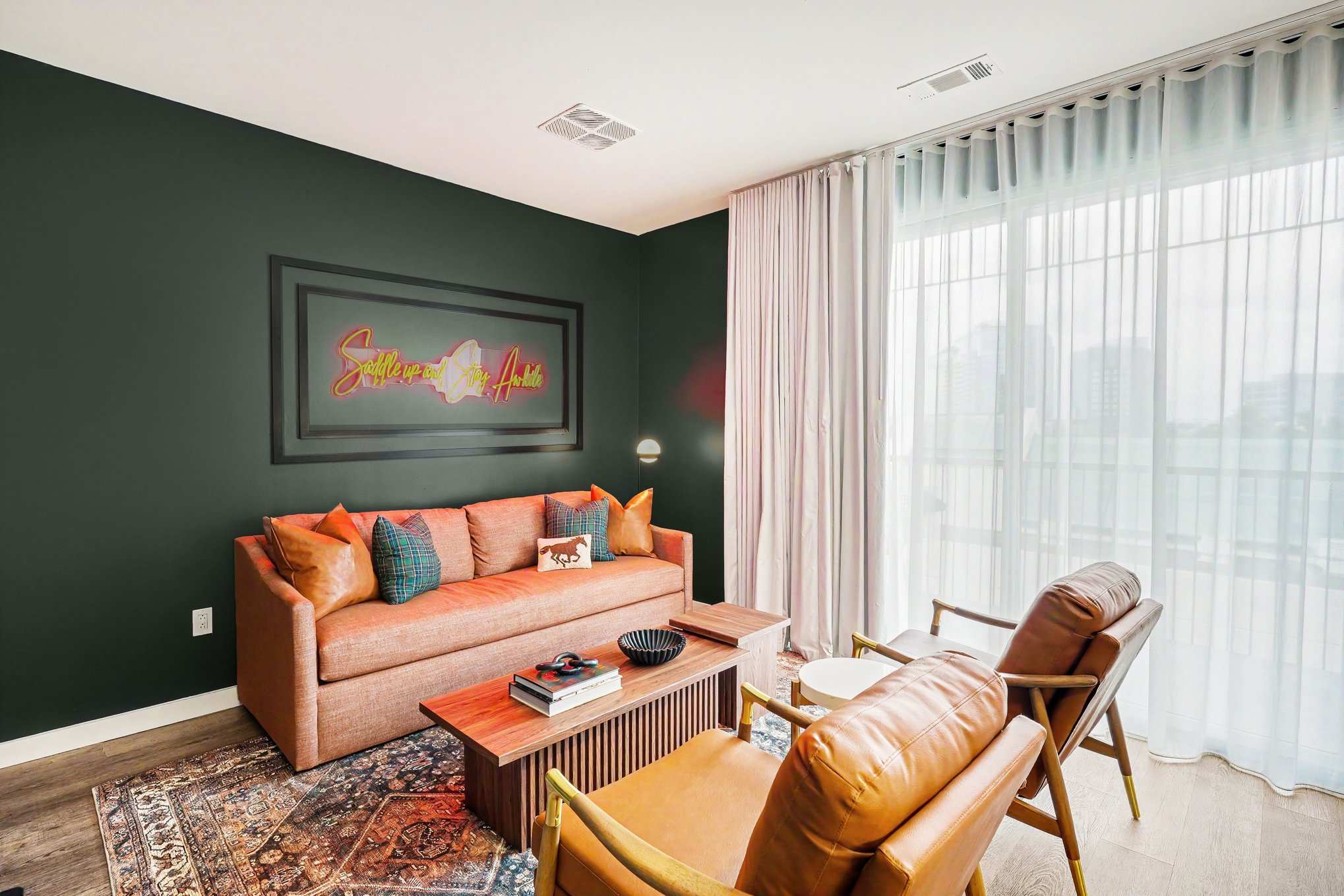 Bright and open living area featuring a smart TV, plush furnishings, and access to the private balcony. Connects to the dining area and kitchen.