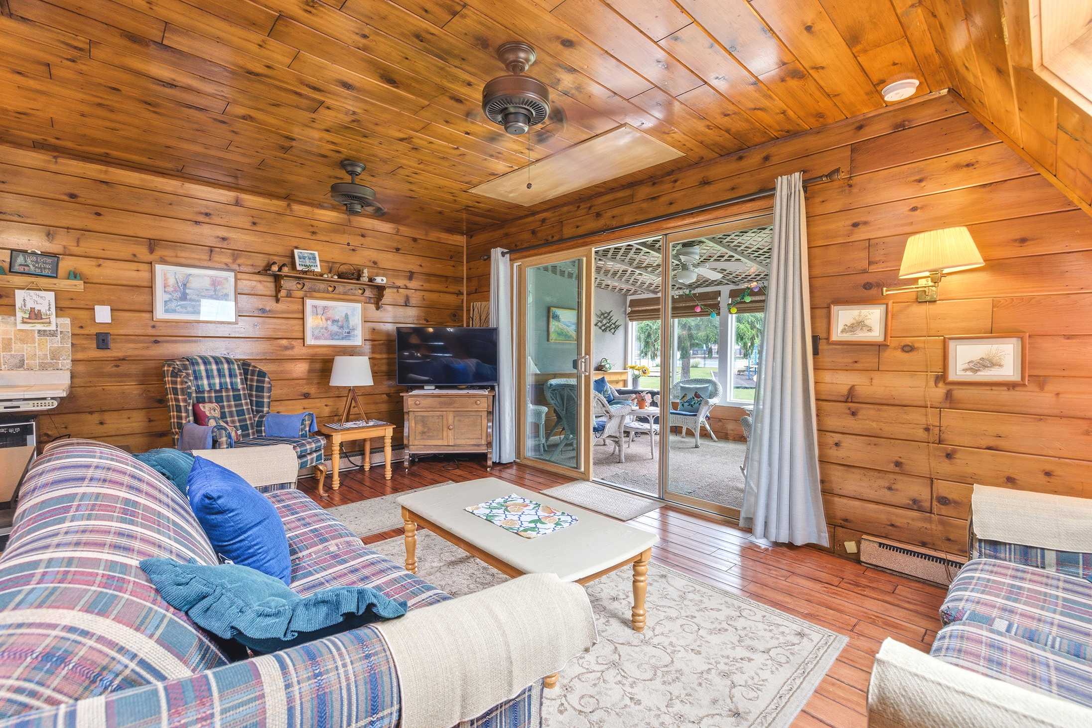 Living room opens to a screened porch overlooking resort amenities.