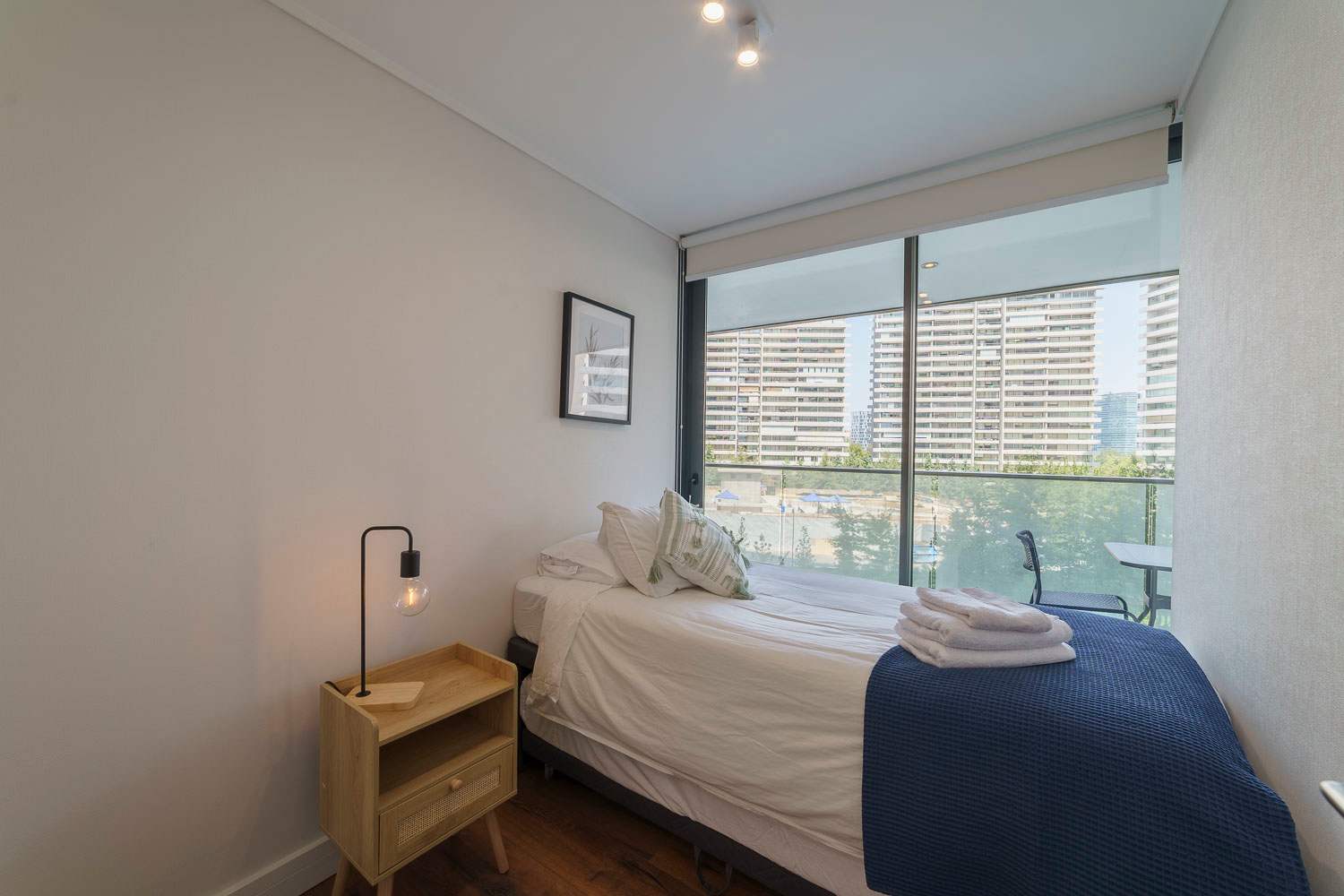 Relax in this cozy bedroom with city views and modern decor, perfect for a restful stay in Santiago.