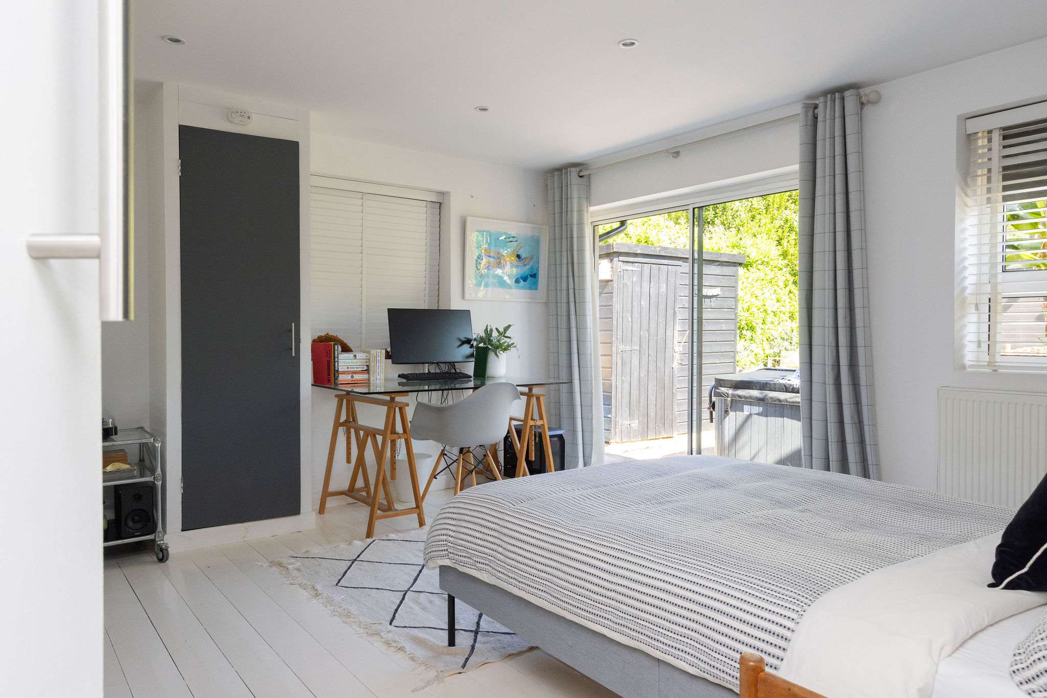 A spacious garden-facing bedroom with desk space and direct outside access