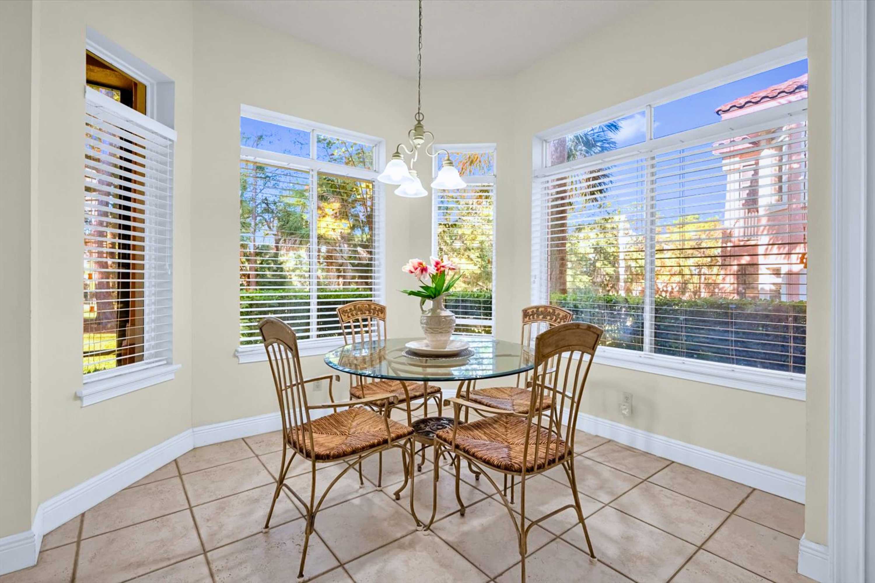 Glass dining table with seating for four overlooking outdoor view