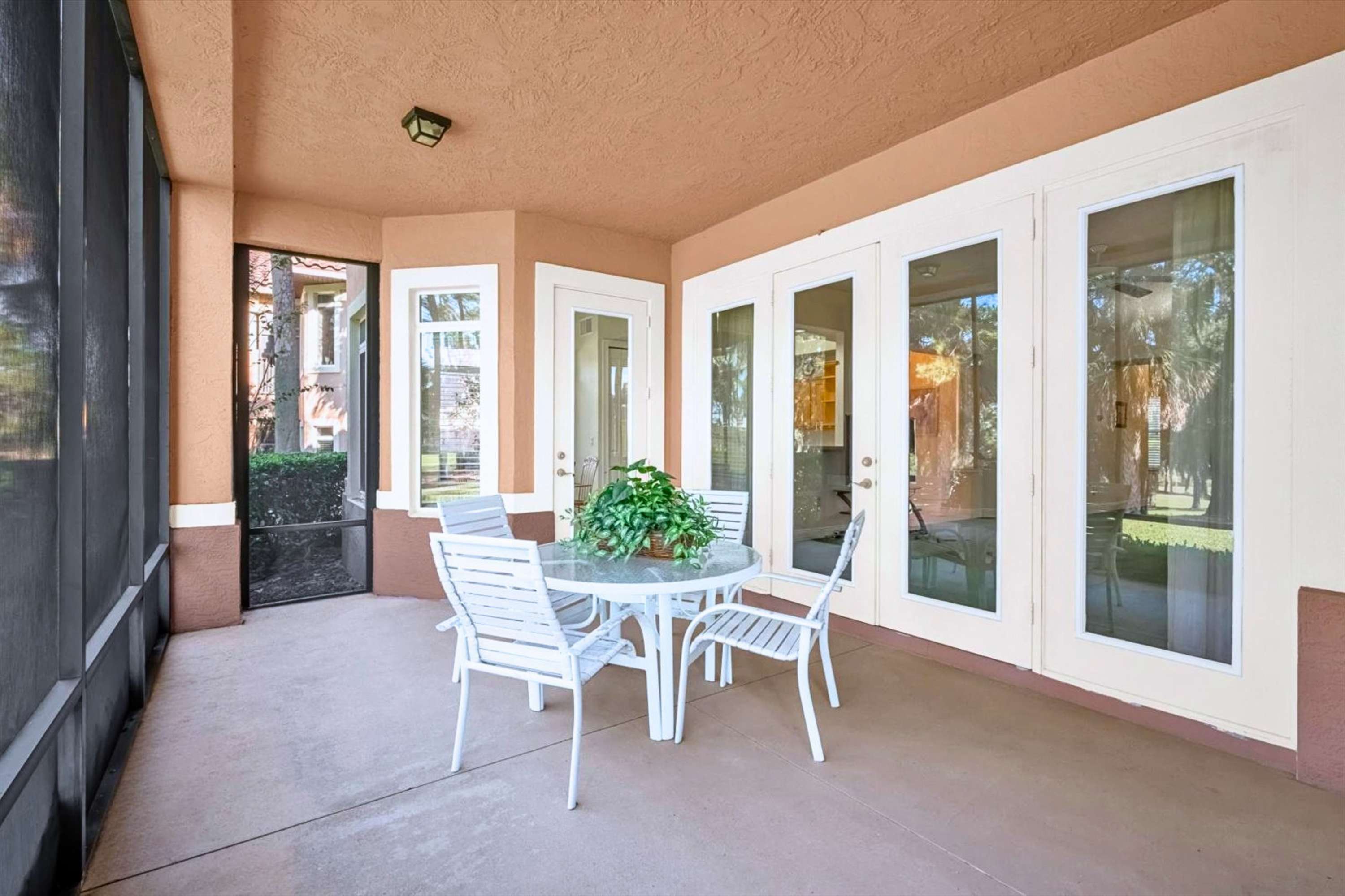 Covered screened in patio with outdoor dining table for 4, ideal for morning coffee or evening meals outdoors
