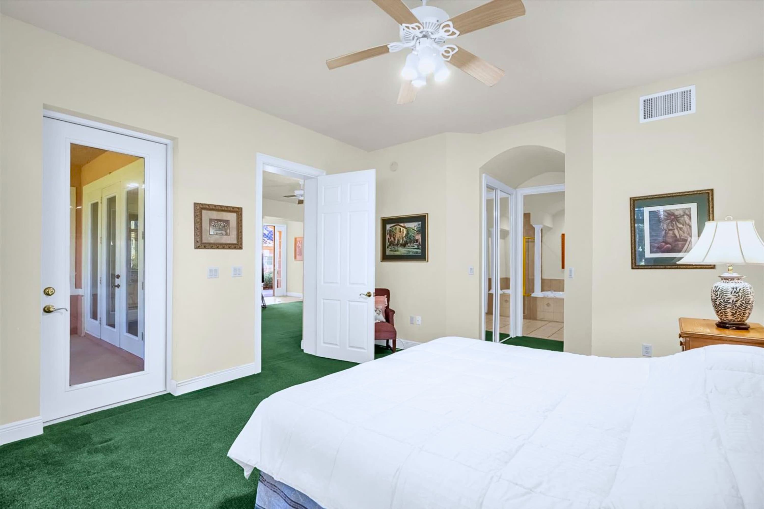 King bed with ceiling fan and convenient bathroom access