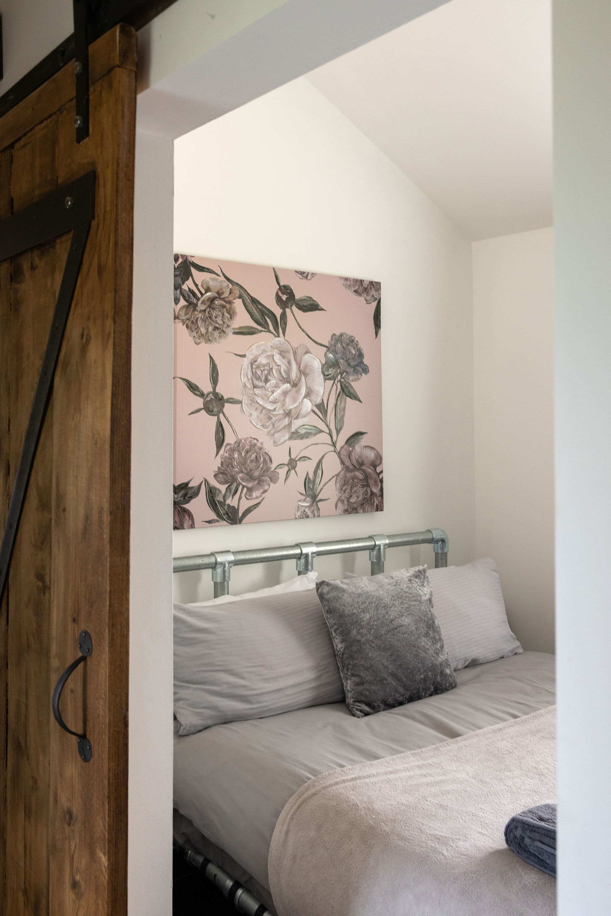 Relax in this tranquil sleeping space featuring beautiful rustic wooden sliding doors.