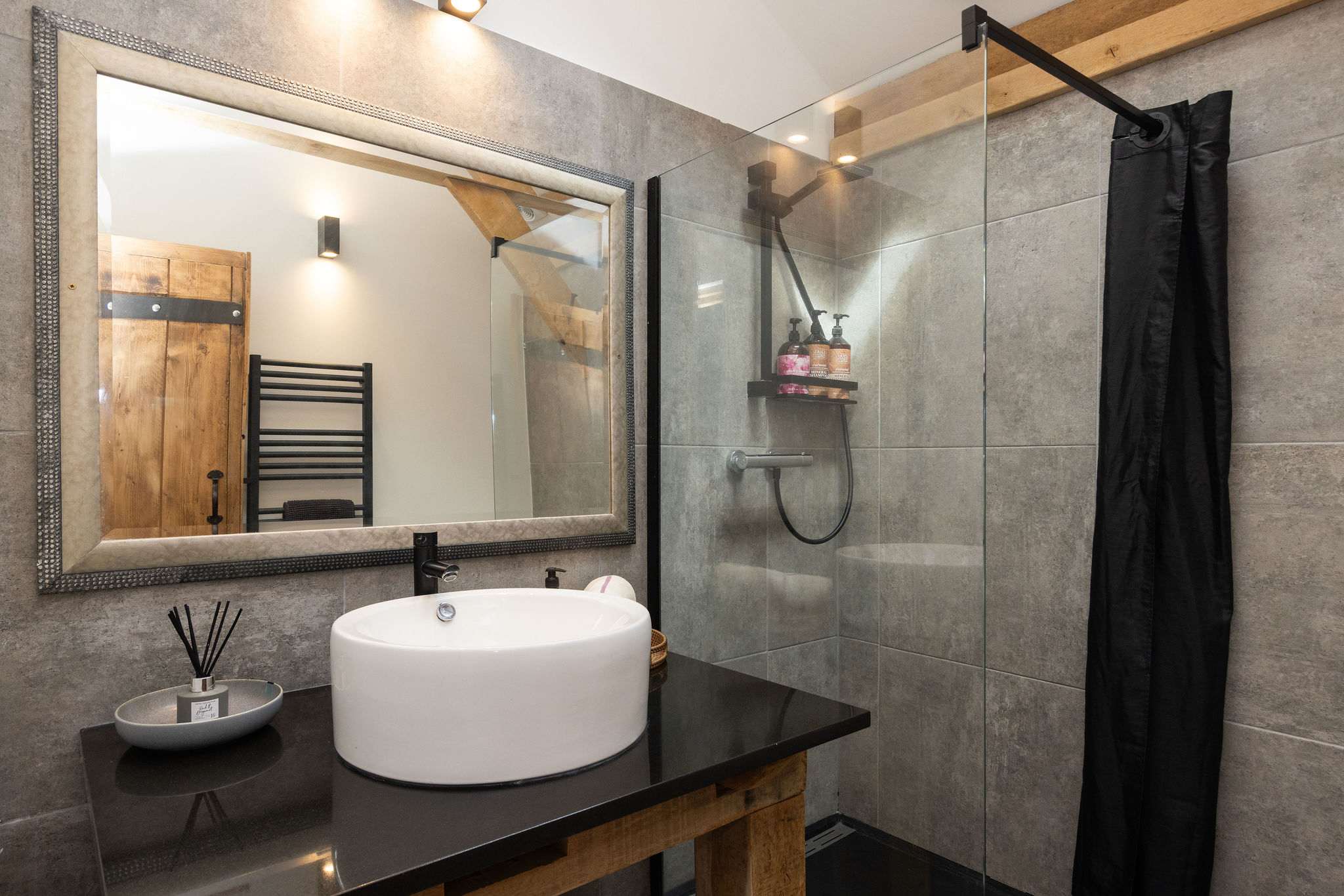 Experience spa-like luxury in this contemporary full bathroom with beautiful stone and wood accents.