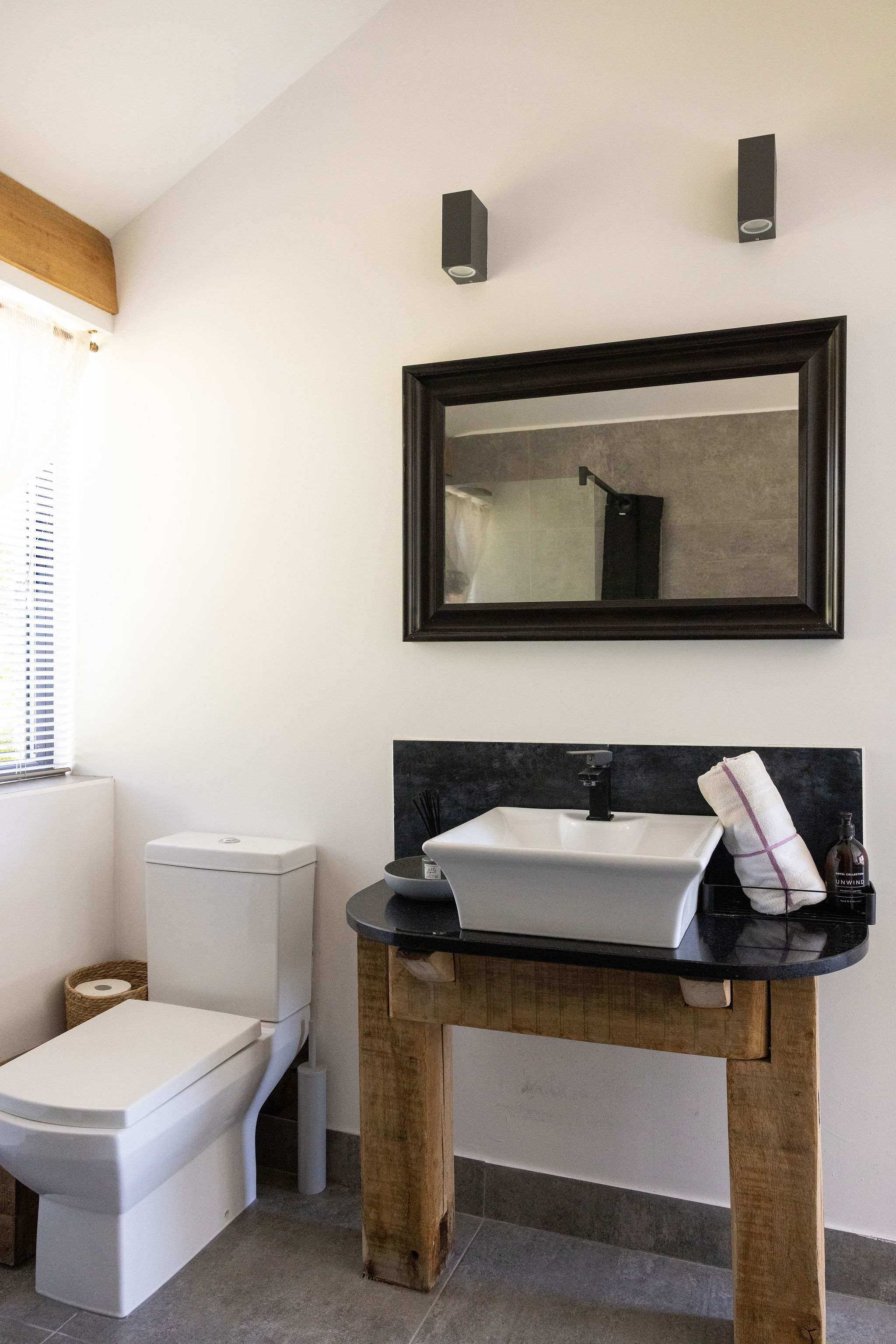 Refresh in this modern bathroom featuring sleek fixtures and stylish rustic wooden details.