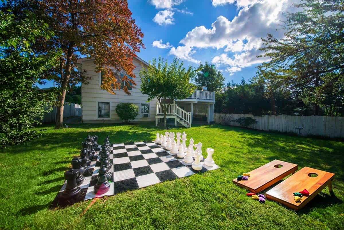 Fenced in backyard with large outdoor chess and firepit.  }}
