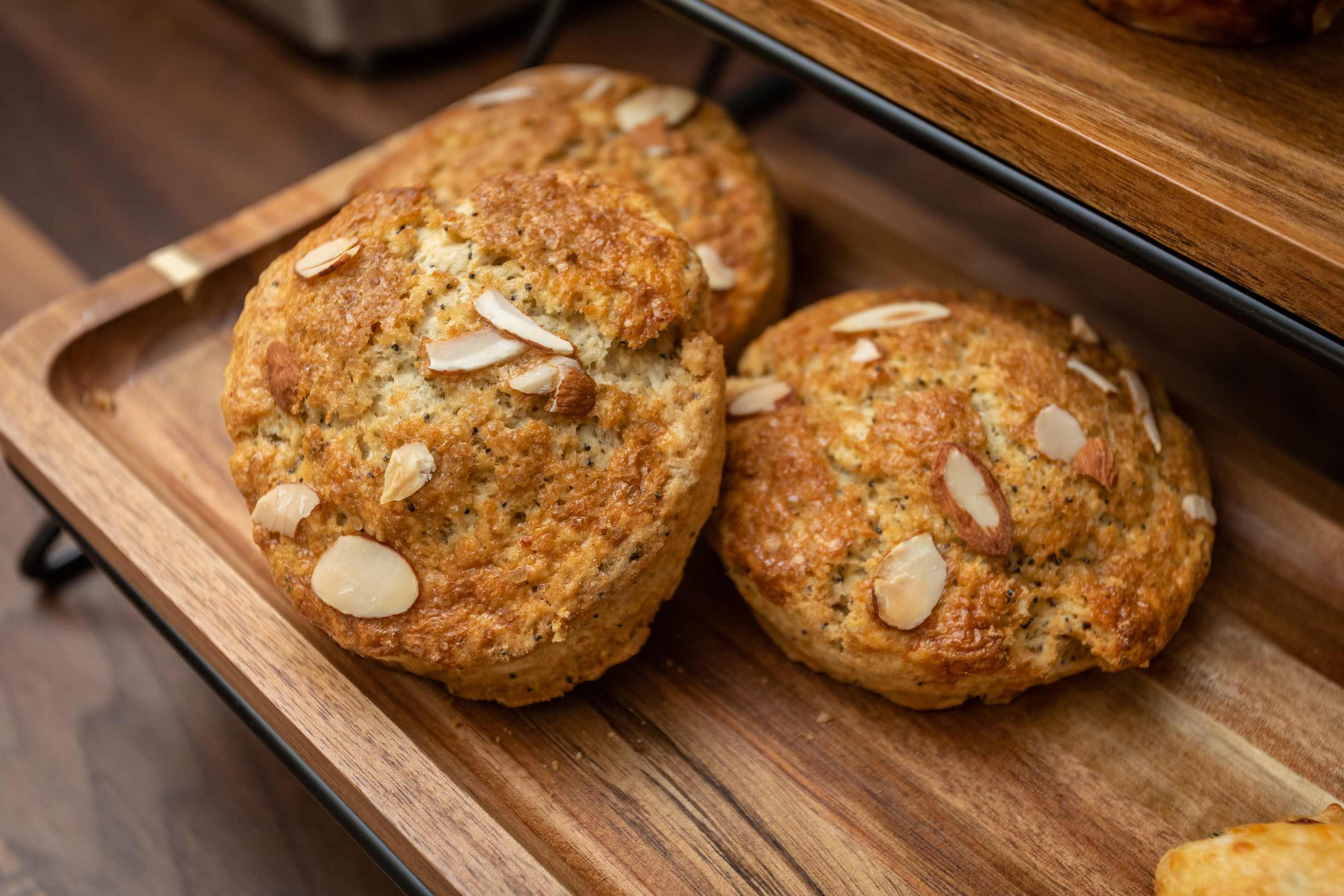 Freshly baked almond cookies displayed on a wooden tray