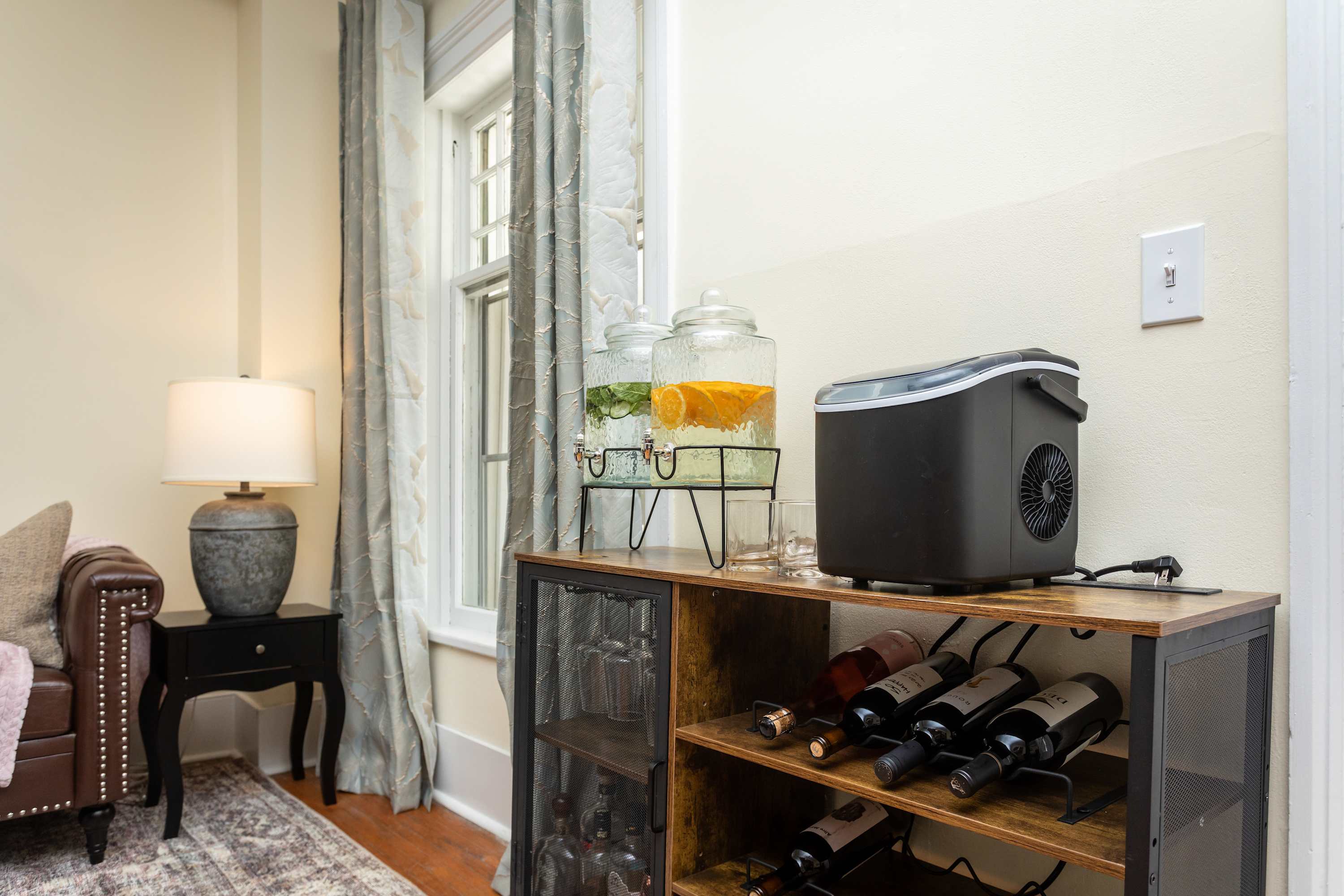 Rustic wine rack and beverage station next to a window with patterned curtains