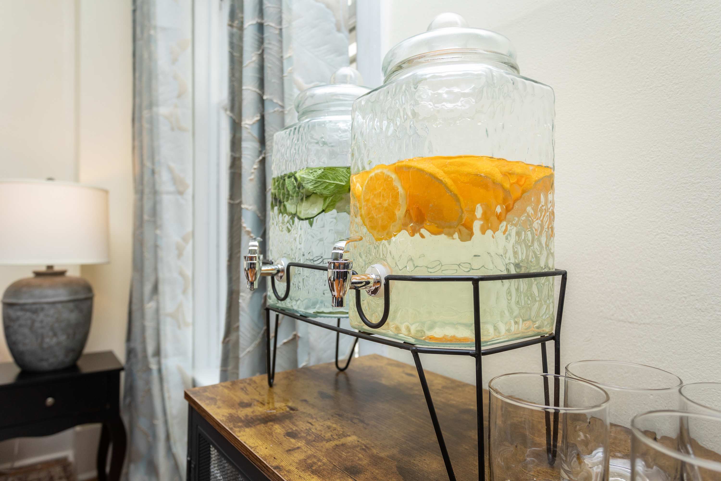 Glass dispensers with infused water offer a refreshing touch in this cozy space.
