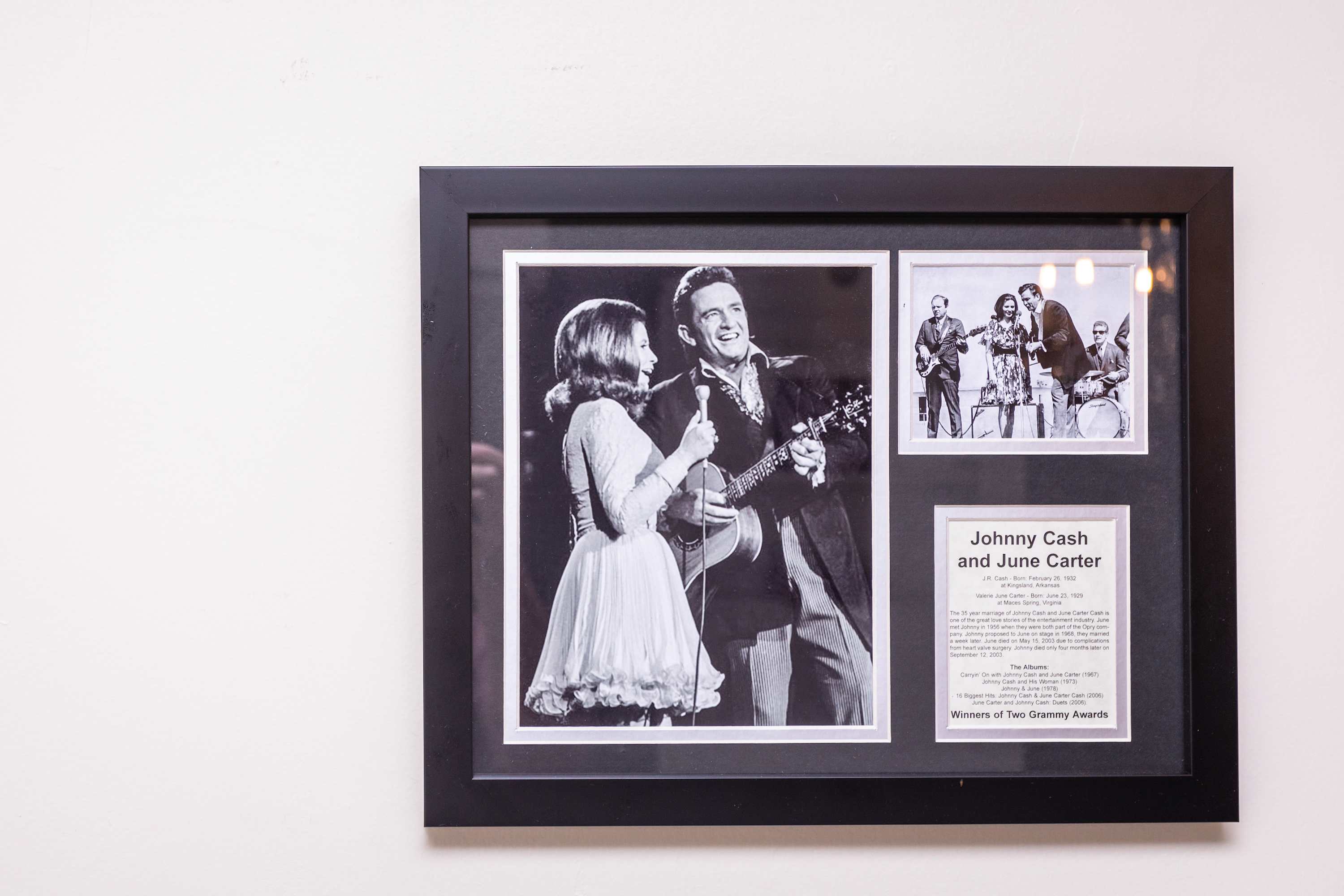 framed black and white photos of johnny cash and june carter on a white wall