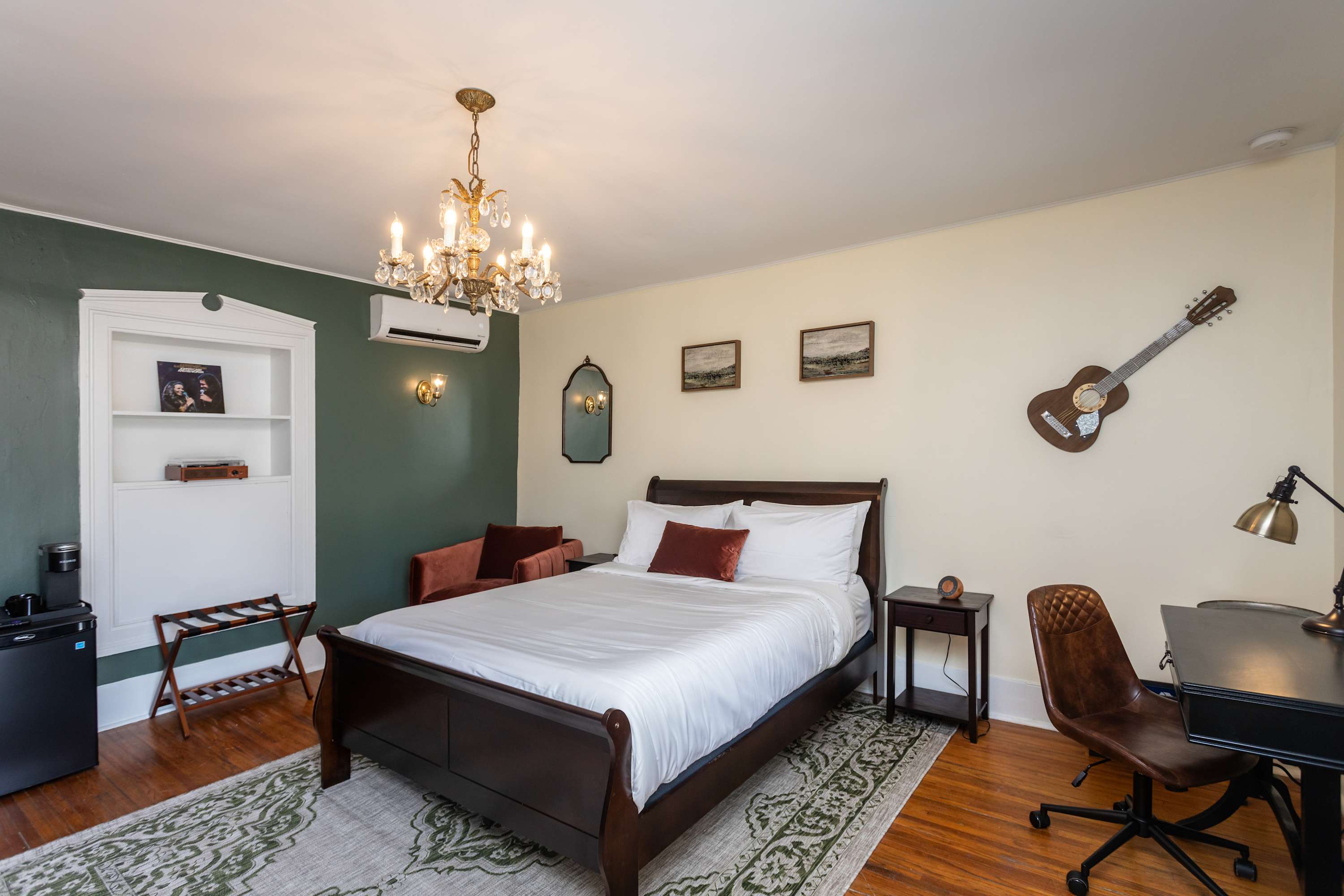 Cozy bedroom with a dark wood bed, vintage chandelier, and a music-themed decor.