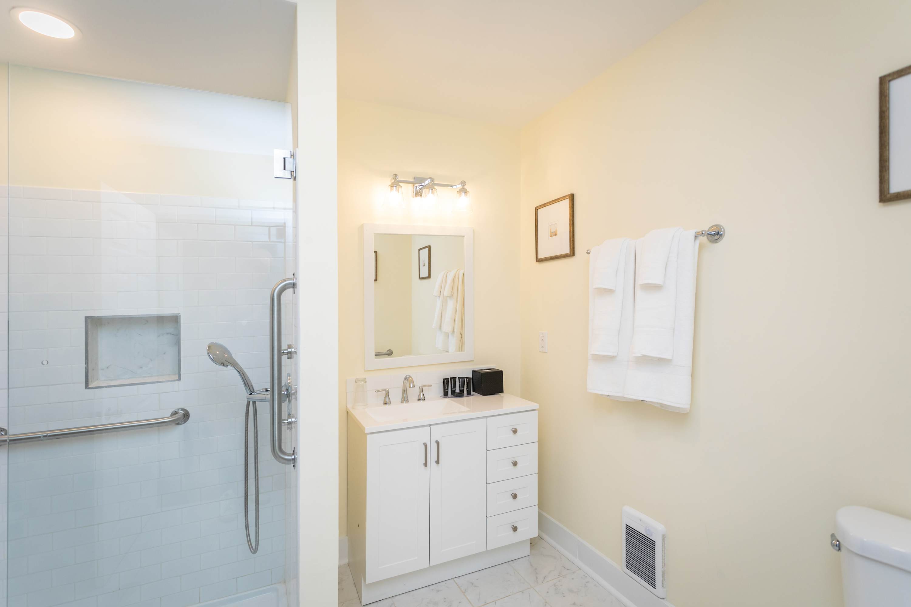 Modern bathroom with a glass-enclosed shower and white vanity.